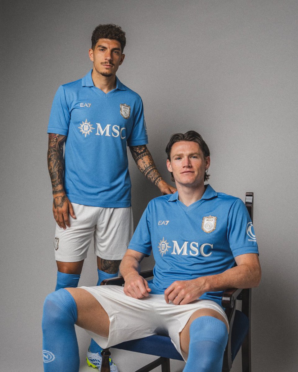 Spazio_Napoli's tweet photo. La nuova maglia del Napoli indossata dai campioni azzurri 😍

Ecco il comunicato ufficiale del club 👇

"SSC Napoli è lieta di presentare la nuova maglia Home 2026/27, che accompagnerà la squadra nella stagione del Centenario.

Un secolo di storia e appartenenza racchiuso in un capo pensato per celebrare le origini del Club e, allo stesso tempo, guardare al futuro. Con questo spirito SSC Napoli ha scelto di raccontare la nuova divisa, che la squadra indosserà durante tutto l’anno, attraverso un video hero capace di unire luoghi e identità. Insieme alla maglia compare la figura di un cavallo, richiamo al Corsiero del Sole, primo simbolo del Club e, da secoli, emblema della passione e dell’indomabilità del popolo partenopeo. Le riprese si muovono dal Vesuvio a Posillipo, attraversando il cuore del centro storico fino al campo dello Scugnizzo Liberato.

La nuova Home è stata realizzata per il sesto anno consecutivo in collaborazione con EA7, che ha lavorato al progetto creativo in sinergia con Valentina De Laurentiis. La divisa nasce guardando alla memoria collettiva dei tifosi napoletani e a una delle maglie più iconiche della storia del Club: quella del primo Scudetto, con il suo azzurro inconfondibile e il richiamo alla lanetta delle divise degli anni Ottanta.

Da questa ispirazione nasce il Centenary Blue, una tonalità speciale che reinterpreta la tradizione attraverso un linguaggio contemporaneo. Il tessuto tecnico richiama visivamente la trama della storica lanetta, fondendo heritage e innovazione.

Elemento centrale della maglia è il crest celebrativo posizionato sul cuore, sintesi visiva dei cento anni di SSC Napoli. Al suo interno convivono quattro simboli: il ritorno del Corsiero del Sole, primo emblema del Club scelto nel 1926 dal presidente Giorgio Ascarelli; il numero 100, che celebra il percorso compiuto dal Napoli dalla sua nascita a oggi; il simbolo dell’infinito, espressione dell’amore senza tempo che lega la città alla sua squadra; e l’attuale logo SSC Napoli, a rappresentare il presente di un Club internazionale, fedele alle proprie radici e proiettato verso il futuro.

La divisa integra armoniosamente i loghi del Main Partner MSC, del Global Technical Partner EA7, del Back-of-Shirt Partner Sorgesana e dello Sleeve Partner Dongfeng. Il retro collo è personalizzato con la scritta “Partenopei”, tributo all’orgoglio di un’intera città.

Tra le novità della stagione c’è la tecnologia NFC, applicata all’interno della patch “Authentic”, che consente di accedere a contenuti esclusivi dedicati al mondo SSC Napoli e rafforza il valore di originalità e autenticità del prodotto.

La maglia garantisce traspirabilità, comfort e libertà di movimento. Gli inserti in rete sotto le maniche favoriscono la ventilazione, mentre lo scollo a V, il colletto stile polo e i bordi manica in costina sono impreziositi da una lavorazione jacquard che dona eleganza ed esclusività al capo.

Il taglio asimmetrico sui fianchi e gli spacchi laterali completano il design con un dettaglio dinamico e contemporaneo. La vestibilità Regular Fit unisce stile e funzionalità, rendendo la nuova Home una maglia pensata per il campo, ma anche per essere indossata ogni giorno dai tifosi".

#SSCNapoli