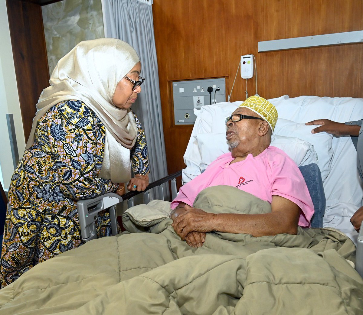 ikulumawasliano's tweet photo. Rais wa Jamhuri ya Muungano wa Tanzania, Mhe. Dkt. Samia Suluhu Hassan akimjulia hali Sheikh Rashid Hamad Othman, Mlezi wa Mwenyekiti wa Taifa wa Chama cha ACT Wazalendo, Mhe. Othman Masoud Othman, anayepatiwa matibabu katika Hospitali ya Aga Khan Jijini Dar es Salaam. Akiwa hospitalini hapo Mhe. Rais Dkt. Samia pia alijulishwa kuhusu kuwepo kwa Mchezaji wa Timu ya Yanga Pacome Zouzoua katika chumba jirani, ambapo alipata muda wa kumtembelea na kumpa pole kufuatia majeraha aliyopata katika mchezo wa Ligi Kuu ya NBC dhidi ya JKT Tanzania katika Uwanja wa Meja Jenerali Isamuhyo hivi karibuni.