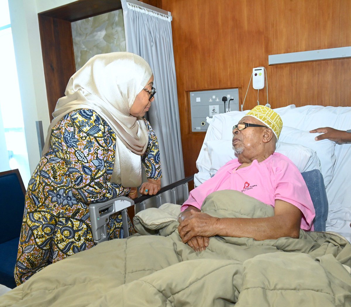 ikulumawasliano's tweet photo. Rais wa Jamhuri ya Muungano wa Tanzania, Mhe. Dkt. Samia Suluhu Hassan akimjulia hali Sheikh Rashid Hamad Othman, Mlezi wa Mwenyekiti wa Taifa wa Chama cha ACT Wazalendo, Mhe. Othman Masoud Othman, anayepatiwa matibabu katika Hospitali ya Aga Khan Jijini Dar es Salaam. Akiwa hospitalini hapo Mhe. Rais Dkt. Samia pia alijulishwa kuhusu kuwepo kwa Mchezaji wa Timu ya Yanga Pacome Zouzoua katika chumba jirani, ambapo alipata muda wa kumtembelea na kumpa pole kufuatia majeraha aliyopata katika mchezo wa Ligi Kuu ya NBC dhidi ya JKT Tanzania katika Uwanja wa Meja Jenerali Isamuhyo hivi karibuni.