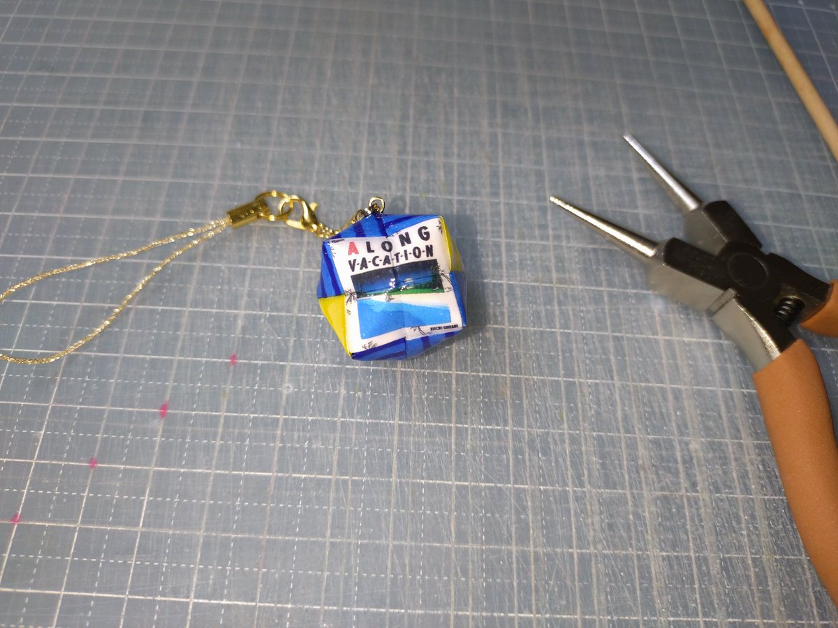 44061's tweet photo. 折り紙で作る極小のくす玉ストラップ

ずっと作ってみたかったジャケ写のくす玉。

『BREEZEが
心の中を通り抜ける』
A LONG VACATION

日本の音楽史に輝く永遠のマスターピースをカバンにつけて出かけてみよう！

#折り紙　#origami #くす玉 https://t.co/n48V9wZIQV