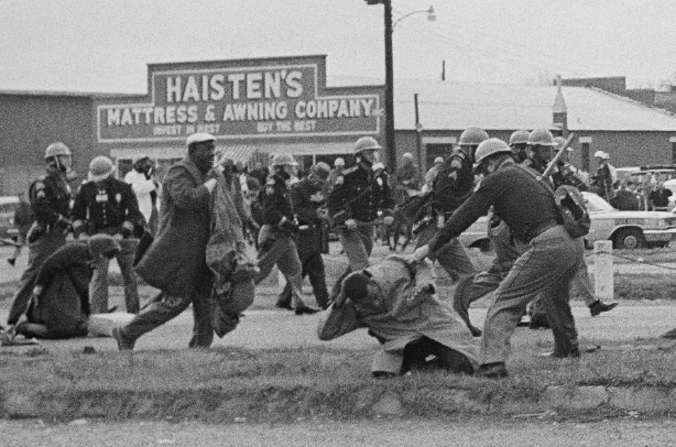 nybct's tweet photo. 黒人の権利のために戦った故ジョン・ルイス下院議員は、自らマーチに参加して警官に殴られ重傷を負った。ルイスは「我々は「静かに」してはいられない」と言い、抗議行動を「良いトラブル」good trouble と言った。手前、警棒で殴られようとしているのがジョン・ルイス。 https://t.co/MBsrrb7eqg