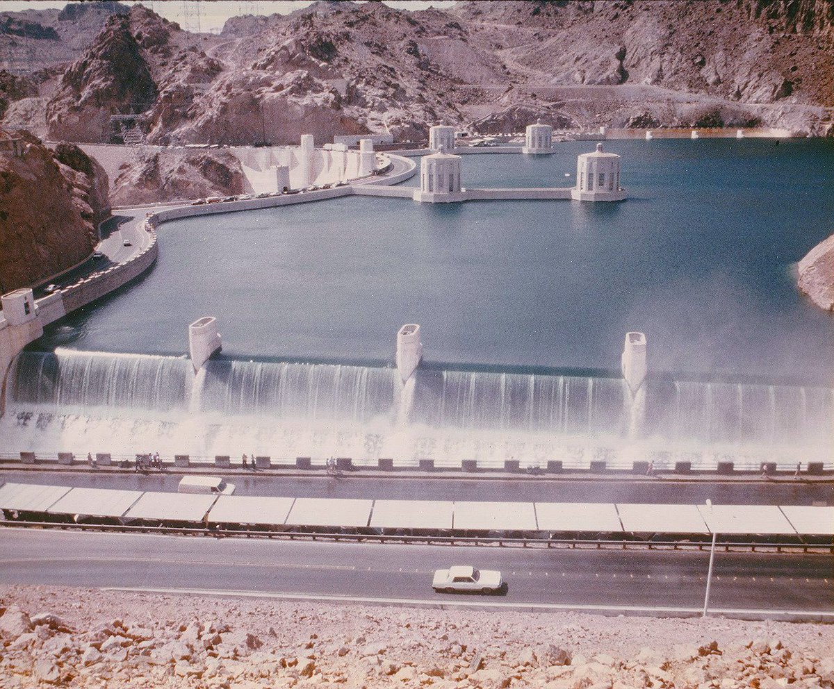 summacorp's tweet photo. July 1983: Lake Mead at 1,225 feet, flowing over the fully raised gates and into the spillway at Hoover Dam. https://t.co/DDqMMLhcyj