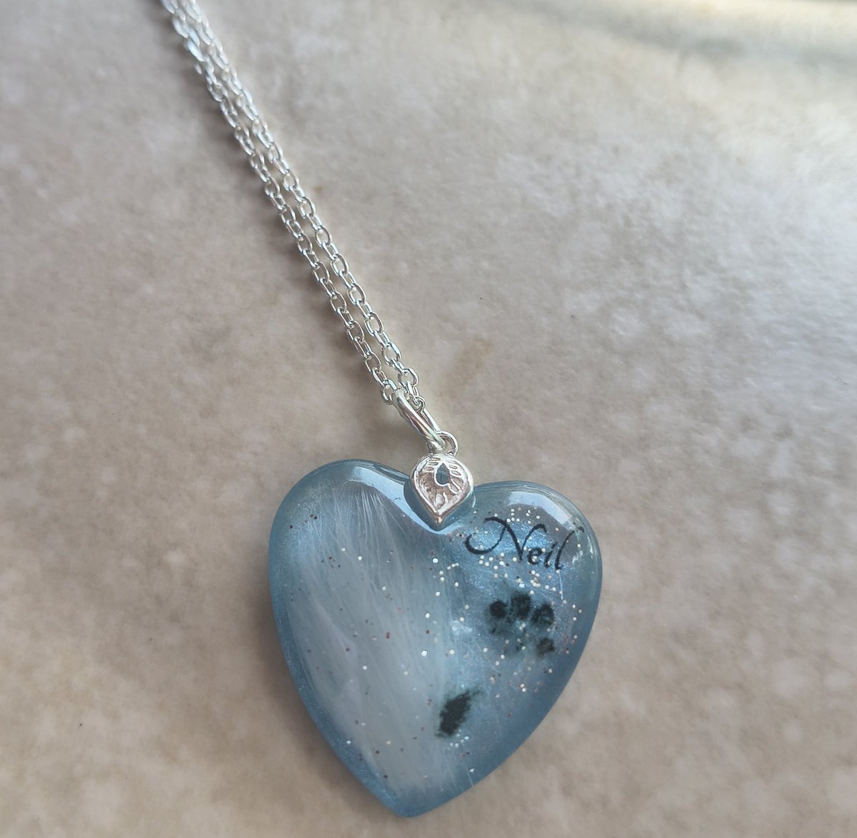 RabbitNeil's tweet photo. 10 weeks since we said goodbye, doesn't feel long yet also feels like a lifetime since you were home. I wanted something to remember him, nothing quite right until I found @CosmicLensJewel his fur, paw print, and name, along with the colour of his eye and a little glitter ♥️💔 https://t.co/OyxZB1xJTc