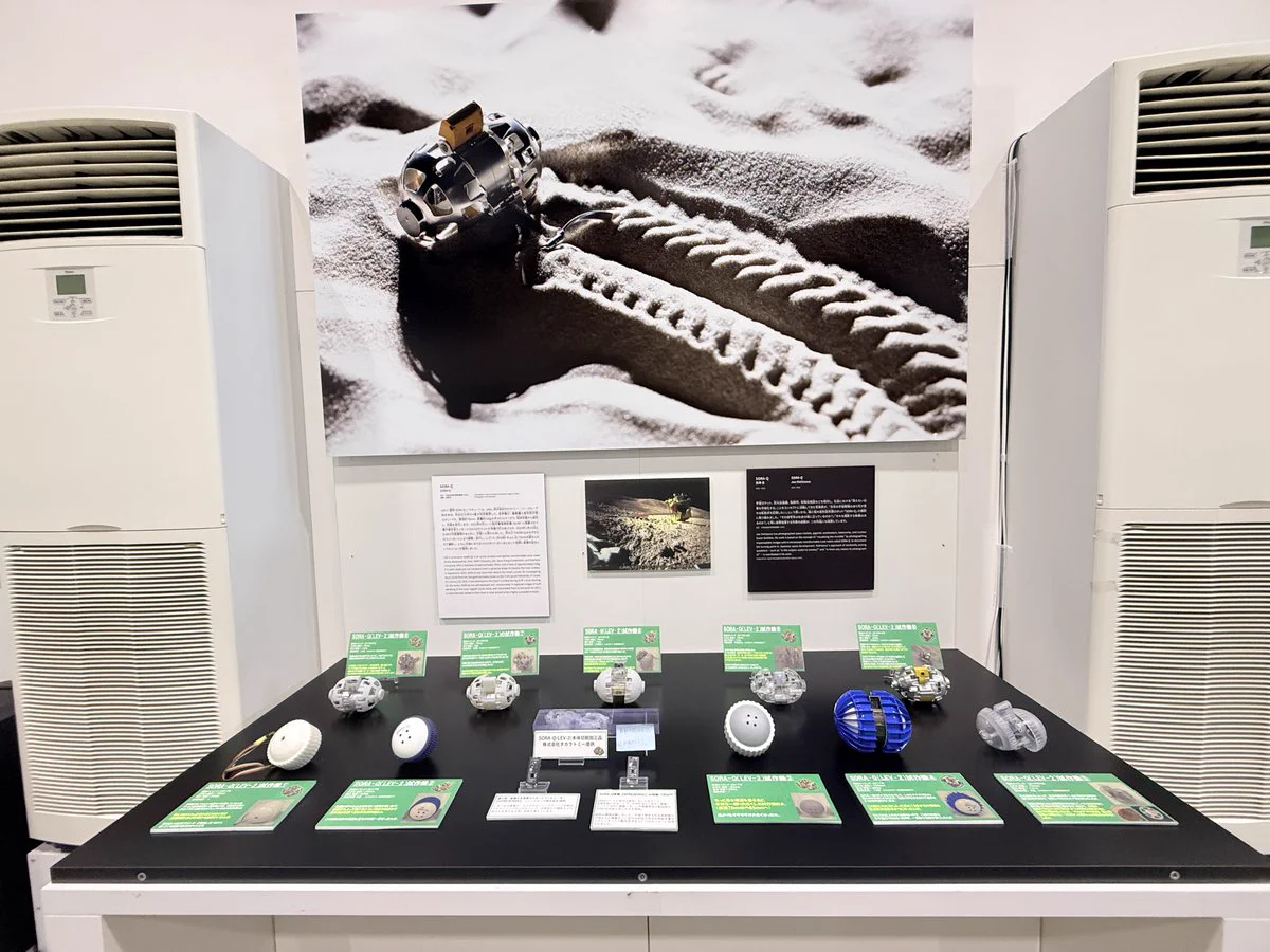 大阪・関西万博にて展示のSORA-Q大型パネルとSORA-Q試作機10機、本体切削加工品、SORA-Q搭載の制御ボードおよび画像処理システムに使用のボードコンピュータ   ©JAXA ／タカラトミー／ソニーグループ㈱／同志社大学