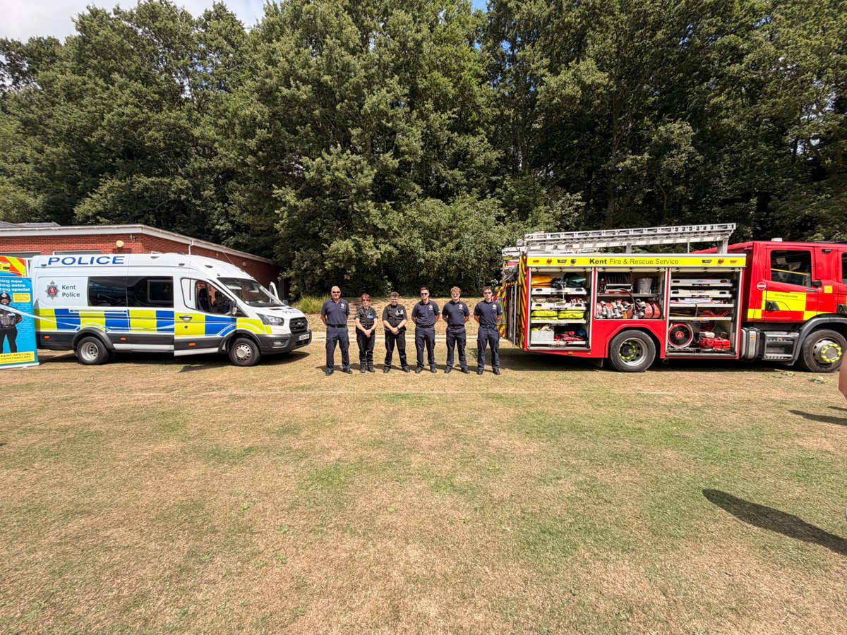 Police officers and Fire and rescue service standing in front of a police van and fire engine.