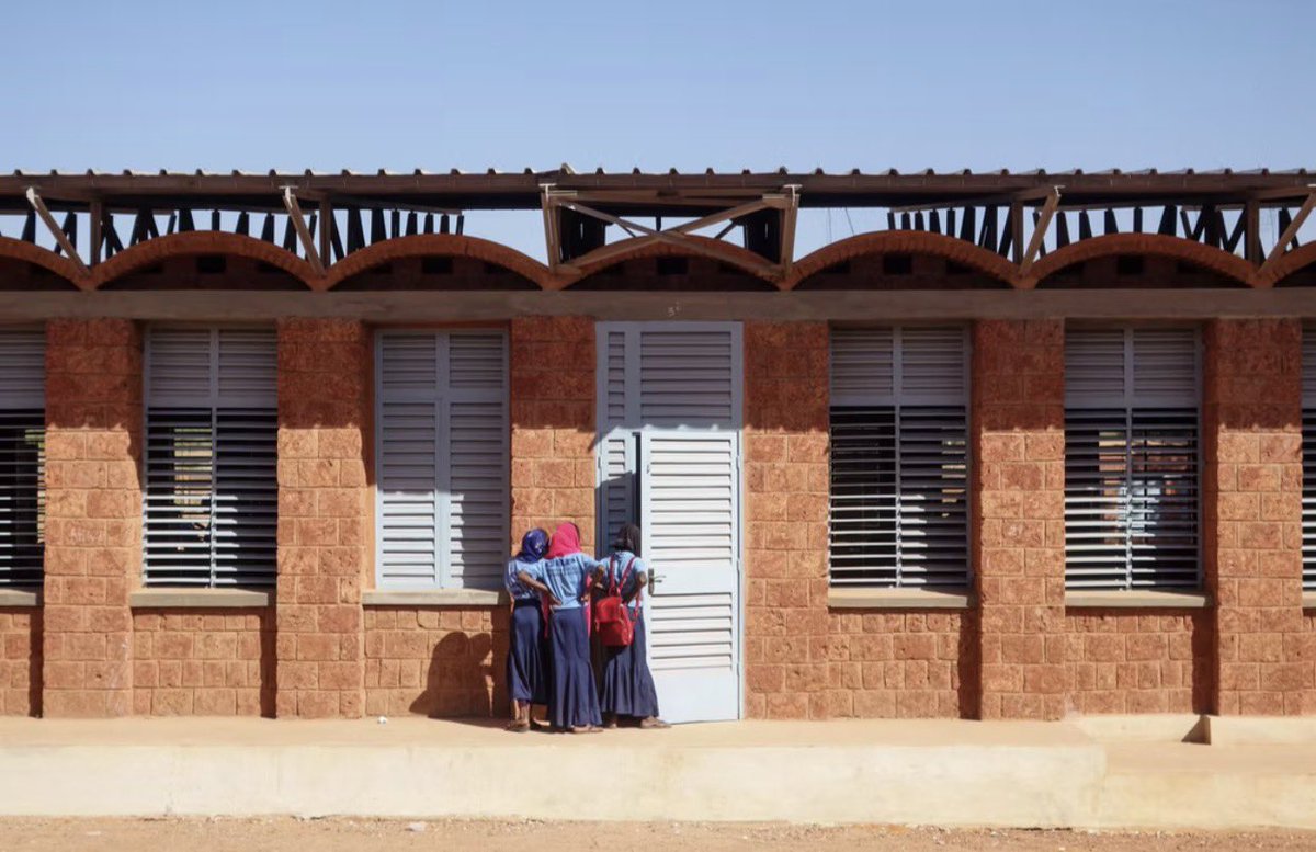 shavnyuyngah's tweet photo. This school in Niger is built of laterite earth, which the region has in abundance. In most cases across Africa, architects and engineers skip the material beneath their feet and go for sand and cement instead, materials that cost more and perform worse in this climate.

Collège Amadou Hampaté Bâ, Niamey, holds 1,200 students. Article 25 built it from laterite block and earth brick, paired with a double roof system, earth vault below, metal canopy above, angled to pull airflow through the gap and block solar heat from reaching the classrooms. Daytime temperatures here regularly cross 40 degrees. Classrooms stay 7 to 8 degrees cooler than outside air by mid afternoon, fully occupied, no mechanical cooling running.

Sand and cement have to be trucked in and priced up. Laterite is under the feet of the people building with it. We keep paying more for the option that performs worse in our own climate.

Plant trees and grass around the compound and the passive cooling compounds, shade cuts ambient heat before it reaches the walls. The building has already proven the concept works. The landscape is the unfinished part.

Architect: Article 25
Location: Niamey, Niger
Completed: 2022
Area: 970 sqm
Materials: laterite stone, earth brick, metal roofing