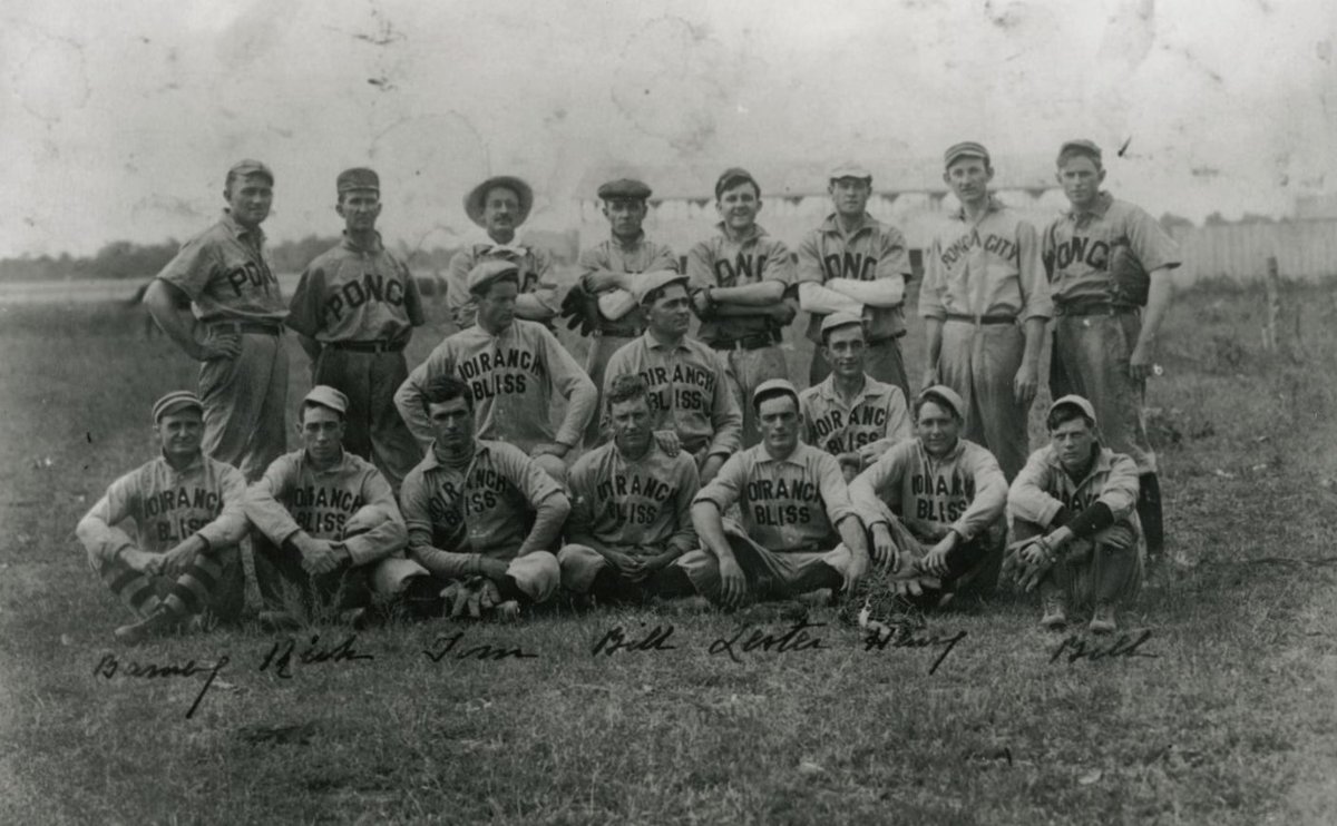 group of men in three rows wearing baseball uniforms pose for a photo