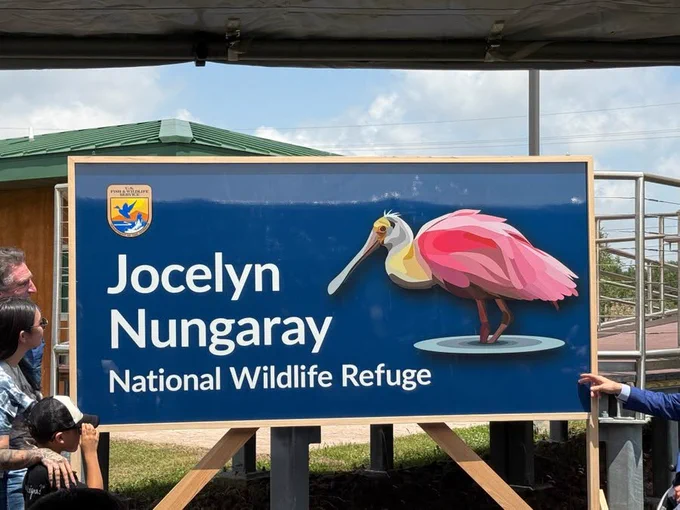 Secretary Burgum stands next to an entrance sign that says Jocelyn Nungaray National Wildlife Refuge.