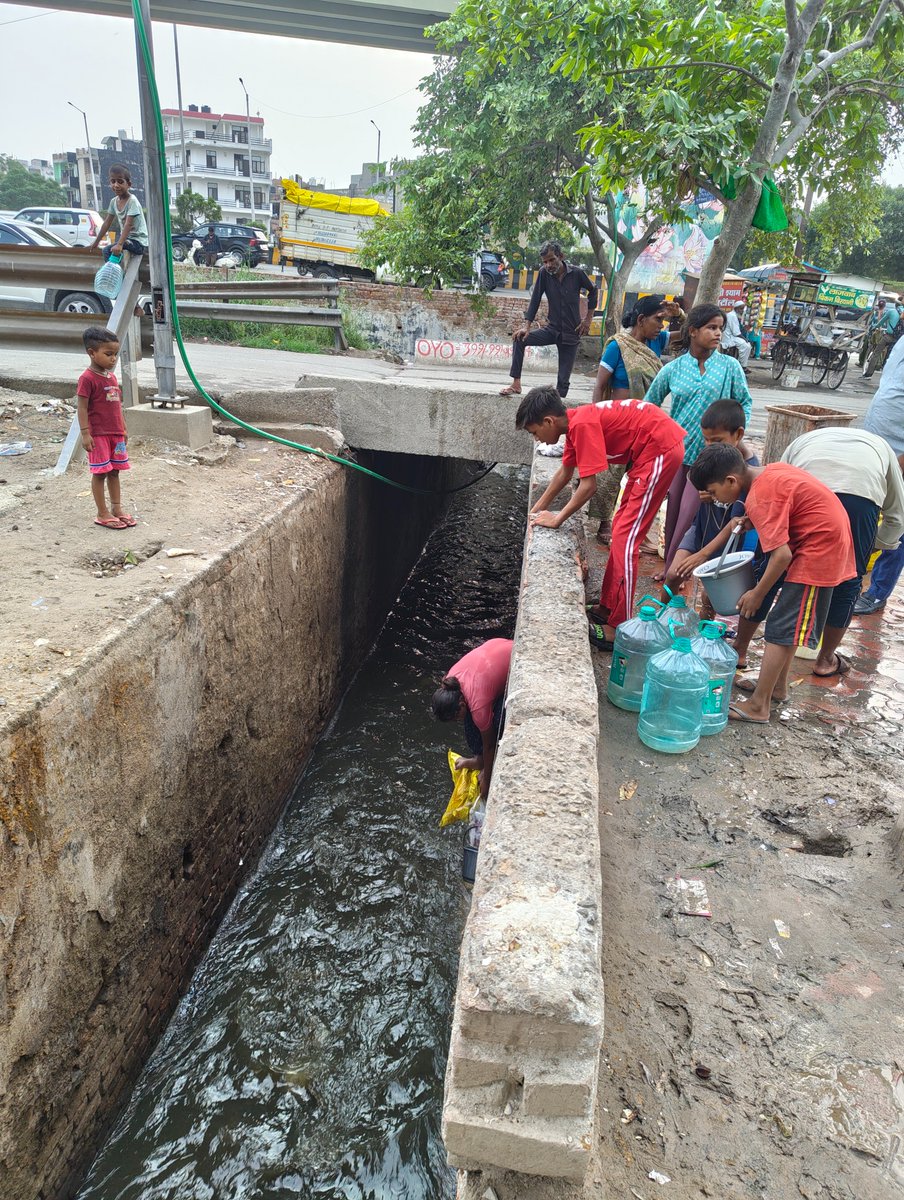 jyotsnooooo's tweet photo. This is sector 78 Noida. Earlier people would huddle around a water tanker in this area, but now, they go down (almost) near the running drain, and fill 'clean' water which is apparently supplying clean water, that pours down the drain. Absolutely shit state of affairs. https://t.co/2XuYhn5OMo