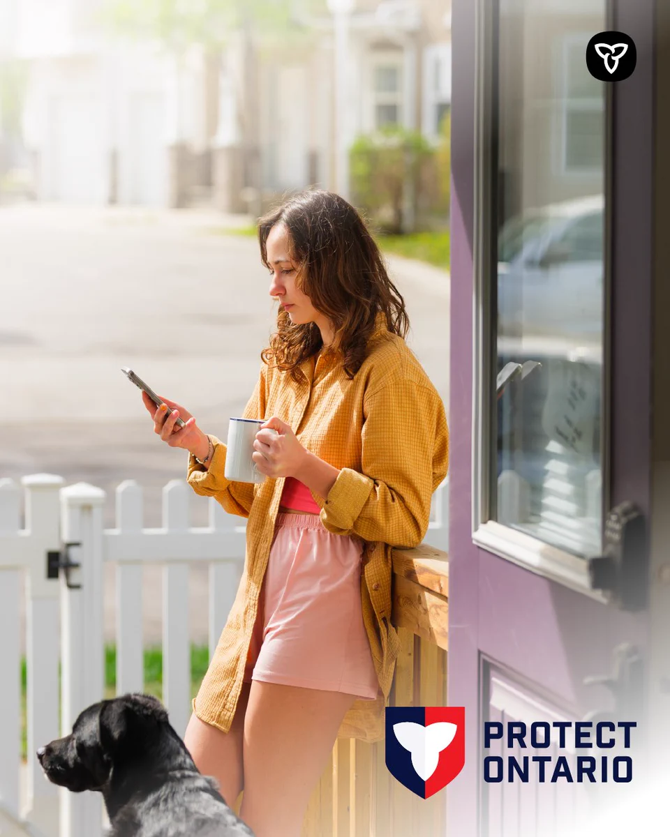 A worried woman using a cellphone on her front porch.