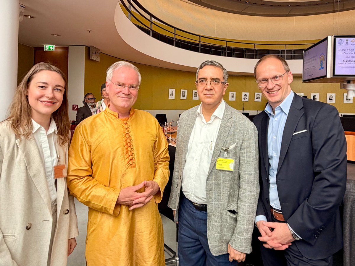 sukadev's tweet photo. Yoga im Deutschen Bundestag. Foto mit MdB Henri Schmidt und His Excellence indischer Botschafter Ajit Gupte 

Anlässlich der Feiern zum International Day of Yoga durfte ich im Deutschen Bundestag über „Yoga in Deutschland“ sprechen – vor Abgeordneten, Vertreterinnen und Vertretern der indischen Botschaft, der indischen Gemeinschaft und der hinduistischen Gemeinschaft.

Meine zentrale Botschaft:

Yoga ist in Deutschland nicht erst angekommen, als Yogamatten in Fitnessstudios lagen.

Yoga und indisches Denken haben Europa – und besonders Deutschland – viel früher und tiefer geprägt, als uns meist bewusst ist.

Manchmal direkt: durch Begegnungen, Übersetzungen, Lehrer, Bücher und Praxis.

Manchmal indirekt: durch Philosophie, Romantik, Psychologie, Naturheilkunde, Lebensreform und moderne Gesundheitskultur.

Und manchmal so tief, dass wir heute gar nicht mehr erkennen, woher manche Selbstverständlichkeiten kommen:

Dass der Mensch seinen Geist schulen kann.
Dass Körper, Atem und Bewusstsein zusammengehören.
Dass innere Freiheit wichtiger ist als äußere Umstände.
Dass Religion nicht nur Glaube ist, sondern Erfahrung werden kann.
Dass Frieden nicht zuerst ein politischer Vertrag ist, sondern eine Fähigkeit des Bewusstseins.
Yoga stammt aus dem Hindu Dharma. Es ist ein großer Strom indischer Weisheit. Und gerade weil Yoga tiefe Wurzeln hat, kann es weit verbinden.
In meinem Vortrag habe ich vier Linien aufgezeigt, in denen Yoga Deutschland mitgeprägt hat:
Selbstbeherrschung, Gleichmut und ethisches Handeln
Innerlichkeit, Selbsterfahrung und die deutsche Romantik

Gesundheitskultur, Naturheilkunde und ganzheitliches Leben

Religion als Erfahrung – nicht nur als Bekenntnis

Yoga ist nicht Weltflucht. Yoga ist Schulung des Menschen, damit er in der Welt klarer handeln kann.
Gerade heute ist das wichtig.
Wir leben in einer Zeit äußerer Krisen und innerer Unruhe. Viele Menschen sind dauernd informiert, aber nicht ruhig. Dauernd vernetzt, aber nicht wirklich verbunden. Dauernd aktiv, aber nicht bei sich.
Yoga stellt eine unbequeme Frage:

Wie wollen wir die Welt ordnen, wenn unser eigener Geist in Unordnung ist?

Bevor wir Frieden fordern, müssen wir Frieden üben.
Bevor wir Dialog verlangen, müssen wir zuhören lernen.
Bevor wir andere führen, müssen wir lernen, uns selbst zu führen.

Dass Yoga im Deutschen Bundestag praktiziert und reflektiert wird, ist ein starkes Zeichen: Die Weisheit Indiens kann beitragen zu Gesundheit, Bildung, Dialog, Demokratie und Frieden.

Herzlichen Dank an Henri Schmidt MdB für die Einladung und Initiative.

Danke an Seine Exzellenz Botschafter Ajit Gupte und die Vertreterinnen und Vertreter der indischen Botschaft für ihre Präsenz.

Danke an Dr. Rajesh Mishra aus Bremen für eine wunderbare Yogastunde.
Danke an Sanjay Tambe für die Meditation mit vedischen Mantras.
Danke an Rakesh Veauli für seine verbindenden Worte als Vertreter der indischen Diaspora.

Und danke an Shankari, Valerie und Jnanadev von Yoga Vidya für ihre Unterstützung und Präsenz.

Ich danke Indien für dieses große Geschenk an die Menschheit. Ich danke den indischen Lehrern, Meistern und Traditionen, die Yoga über Jahrtausende bewahrt haben.

Möge Yoga in Deutschland nicht nur populär bleiben, sondern tief.

Nicht nur Bewegung, sondern Bewusstsein.
Nicht nur Entspannung, sondern Transformation.
Nicht nur Methode, sondern Brücke.

Namaste.