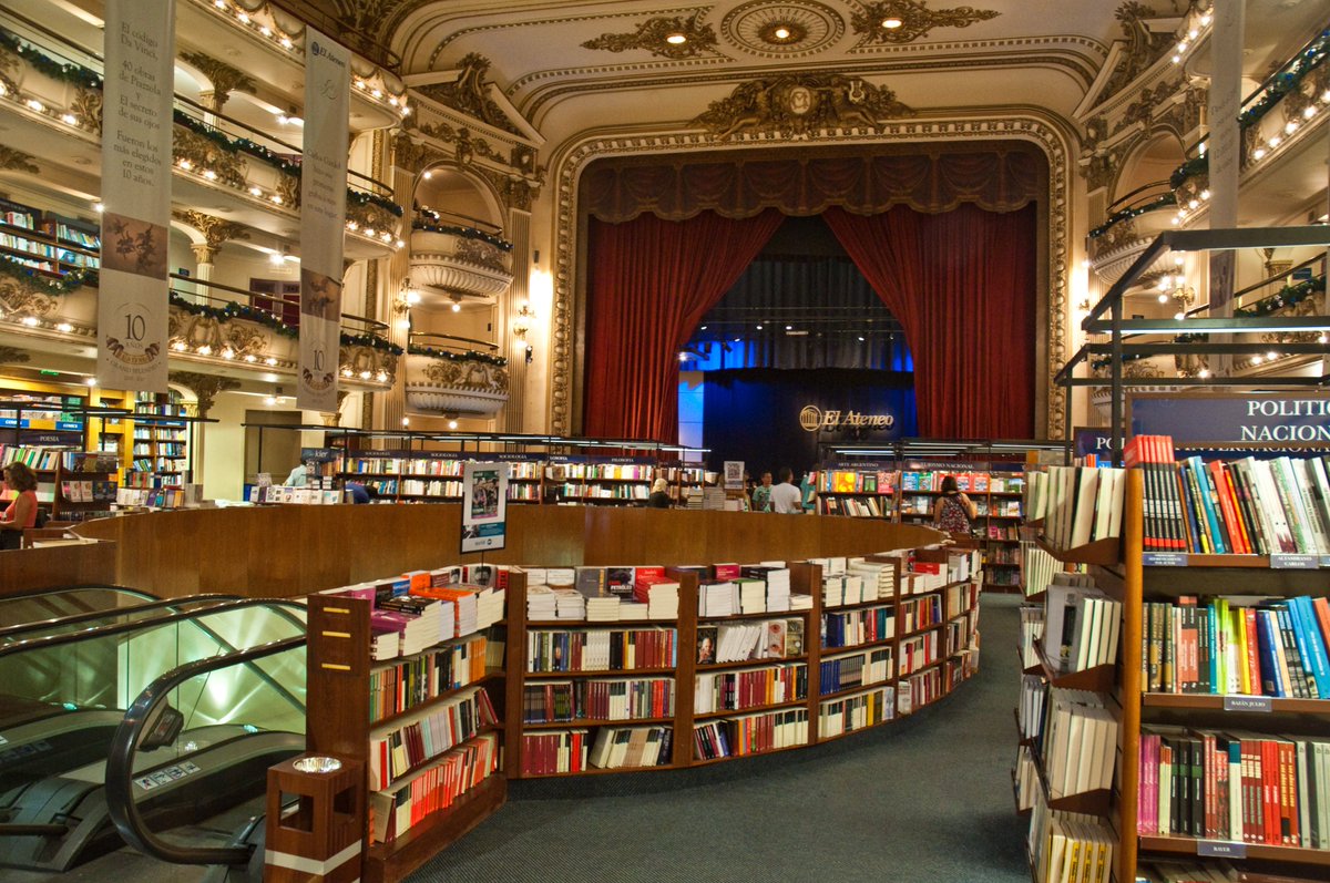 mrtktypv's tweet photo. Fotoğrafçıların ve kitapseverlerin dünyadaki kutsal mekanlarından biri Arjantin’dedir: El Ateneo Grand Splendid. 1919 yapımı görkemli bir tiyatro binasından bozma bu kitapçı, neden dünyanın en çok fotoğraflanan kapalı mekanlarından biri?

Buenos Aires'teki bu mekan, tavanındaki el yapımı freskleri, orijinal tiyatro locaları, kırmızı kadife perdeleri ve devasa sahnesiyle korunmuş bir mimari harikasıdır. Ancak burayı fotoğrafçılar için cazip kılan şey ışık yönetimidir.

Eski tiyatro ışıklandırma sistemi, kitap raflarını aydınlatacak şekilde yeniden tasarlanmıştır. Bu yüzden yukarıdaki localardan geniş açı bir lensle çekim yaptığınızda, sanki bir kitapçıyı değil, edebiyatın sahnelendiği devasa bir operayı fotoğraflıyormuşsunuz hissi verir.

Akıllı telefonların kameralarını en çok zorlayan iç mekan kontrastı ve sarı ışık dengesi (White Balance), bu büyüleyici kitapçıda adeta bir görsel şölene dönüşüyor.