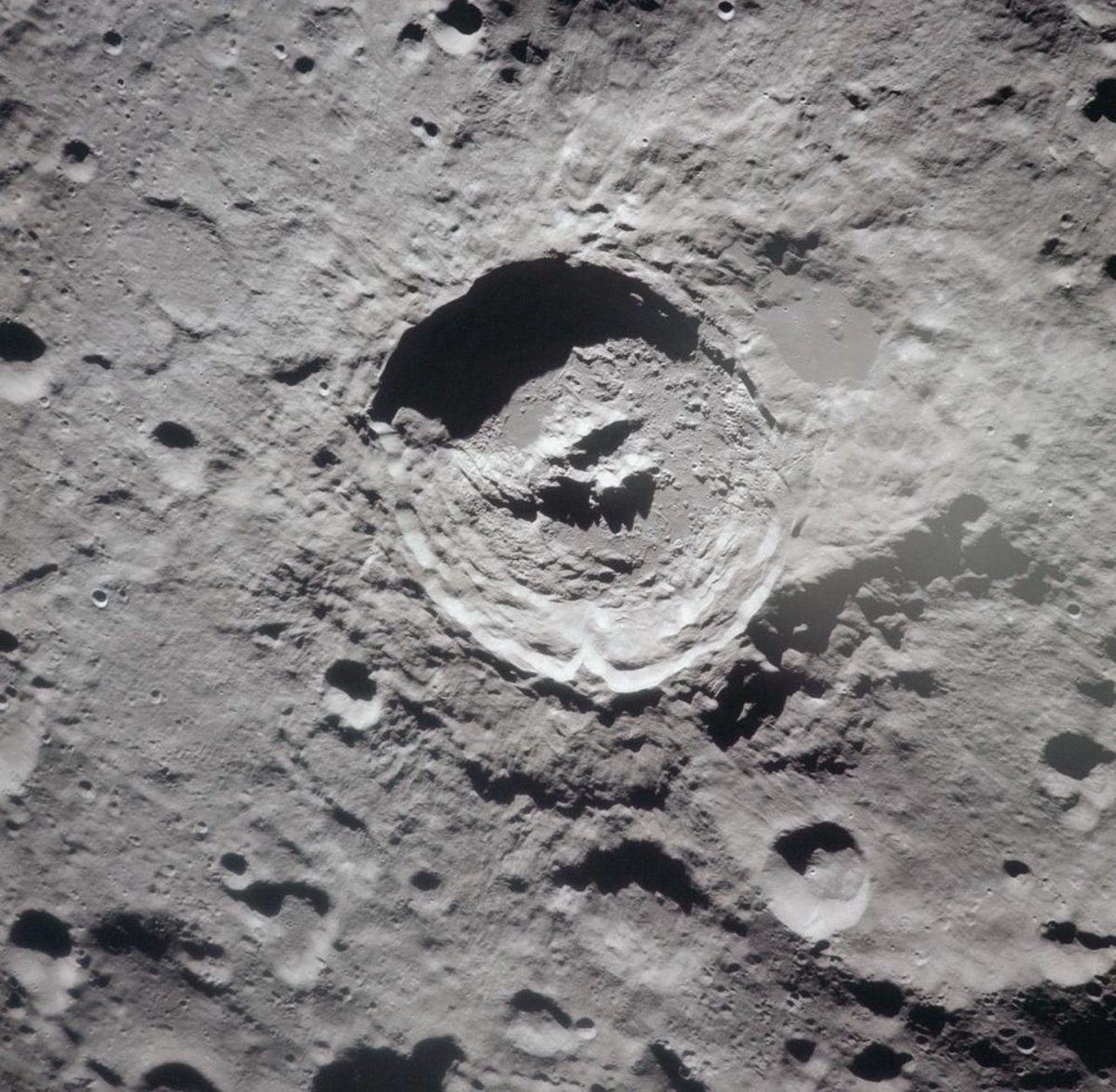 UAPConvergence's tweet photo. Additional thoughts: The claim that alien objects have been seen on the moon goes back to 1976. People without knowledge of the history of this subject might not be aware.

We should talk about the 1976 book Somebody Else Is on the Moon by George H. Leonard. In that book, Leonard argued that NASA lunar photographs showed evidence of artificial activity on the Moon, including what he called “X-drones.”  

The key points were:

Leonard believed the X-shaped objects were enormous autonomous machines.

He proposed they were involved in mining, excavation, and rock processing on the lunar surface.

He described them as being capable of changing configuration or function, almost like modular robotic construction equipment rather than conventional vehicles.  

His interpretation relied heavily on Apollo-era NASA photographs, which he believed contained overlooked evidence of artificial structures, machinery, geometric features, and lights.

He did not claim the images were redacted by NASA. Instead he said the objects were overlooked. 

Nothing regarding his claims has been verified officially. All are considered cases of normal pattern recognition (pareidolia).

Images: 

Official NASA images which Leonard claimed demonstrated mining operations with X drone machines.

A sketch by Leonard of what he termed X drones; large mechanical apparatus that posssed flexible arms for mining.