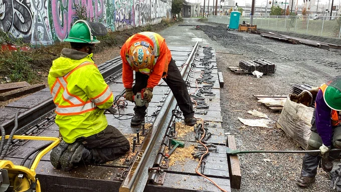 Workers disassemble old train tracks along East Marginal Way.