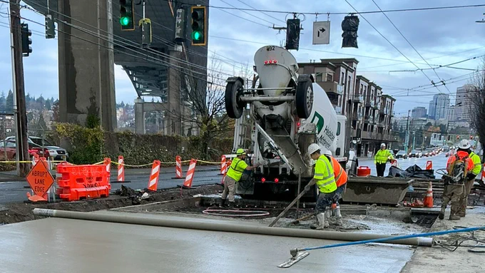 Workers pour concrete for a new street surface in Eastlake.
