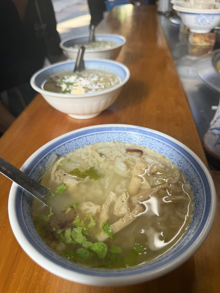 tokyodegu's tweet photo. ホテルからバイクの滝まで歩いて帰り道に朝飯。『大稻埕米粉湯』で台湾雑炊のお店で2人はビーフンぽいと米のミックス、自分は米のみで。豚肉と内臓がたっぷり煮詰められたスープが美味しい。今回もセンピ〜さんの店チョイス。目の前で調理を見ながら食べれる路面屋台風でローカル感たっぷり。横のおば、、マダムが『おいしい』の言葉に反応して日本語で話しかけてくれたり、おいしい！って言ってるよって店のおば、、マダムシェフに伝えてくれたり。身も心もポカポカする粥でした。オヌヌメ★３つ。