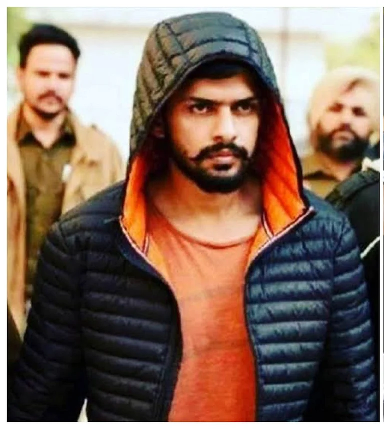 Siddhantmt's tweet photo. पढ़िए, लॉरेंस बिश्नोई पर अमरीका के जस्टिस डिपार्टमेंट ने क्या आरोप लगाए हैं - 

1 जुलाई को एक अमेरिकी अदालत (फेडरल ग्रैंड जूरी) द्वारा दायर किए गए एक आरोप-पत्र के अनुसार, भारत के पंजाब का रहने वाला 33 वर्षीय लॉरेंस बिश्नोई लंब�� समय से भारत की जेल में बंद एक गैंगस्टर है। अपराध की दुनिया में आने से पहले वह खुद को यूनिवर्सिटी का छात्र नेता बताता था, लेकिन बाद में राजनीति से ऊबकर उसने और उसके साथियों ने जुर्म का रास्ता चुन लिया।

जनता के सामने बिश्नोई ने सोशल मीडिया और न्यूज़ चैनलों के इंटरव्यू के ज़रिए खुद को एक "देशभक्त", "राष्ट्रवादी" और बहुत ही धार्मिक इंसान के रूप में पेश किया। उसने अपनी इस छवि का इस्तेमाल भारत, अमेरिका और अन्य देशों में अपने क्राइम सिंडिकेट में नए लोगों को शामिल करने के लिए किया।

लेकिन गुपच���प तरीके से, बिश्नोई एक बहुत बड़े आपराधिक नेटवर्क को चला रहा था जो कई महाद्वीपों में फैला हुआ था। जेल की अपनी कोठरी में छिपाकर लाए गए मोबाइल फोन और इंटरनेट कॉलिंग डिवाइस का इस्तेमाल करके, बिश्नोई ने दुनिया भर में अपने गिरोह के लोगों से राजनेताओं की हत्या, मर्डर, गोलीबारी, जबरन वसूली (हफ्ता ��सूली), अपहरण, ड्रग्स की तस्करी, मानव तस्करी और अन्य अपराध करवाए।

सितंबर 2025 में कनाडा सरकार ने बिश्नोई के गिरोह को एक आतंकवादी संगठन घोषित कर दिया था।

अपने गिरोह के रोज़मर्रा के कामकाज को संभालने के लिए, बिश्नोई ने अपने भरोसेमंद साथियों और क्षेत्रीय नेताओं को ज़िम्मेदारी सौंपी। इनमें बिश्नोई गिरोह का उत्तरी अमेरिका का लीडर 32 वर्षीय सतिंदरजीत सिंह उर्फ "गोल्डी बराड़" (पंजाब, भारत), यूरोप का लीडर 37 वर्षीय रोहित गोदारा (राजस्थान, भारत) और 58 वर्षीय सुखराज सिंह कांग (पंजाब, भारत) शामिल थे। बराड़ और गोदारा बिश्नोई के इशारे पर ही काम करते थे और उन्होंने ही अमेरिका, कनाडा व अन्य देशों में गिरोह के लोगों से हिंसक घटनाओं को अंजाम दिलवाया।

इस गिरोह ने अमेरिका सहित हर उस देश में हिंसक वारदातों को अंजाम दिया जहाँ वे सक्रिय थे। उन्होंने खासकर भारत और दुनिया भर में रहने वाले भारतीय समुदायों क�� बीच डर का माहौल पैदा करने के लिए हिंसा का सहारा लिया। गिरोह ने ऑनलाइन वीडियो और इंटरनेट पोस्ट के ज़रिए अपने अपराधों का प्रचार करके लोगों को डराया और उनसे जबरन पैसे वसूले।

आरोप-पत्र में जिन अपराधों का ज़िक्र है, उनमें भारत के पंजाब राज्य के एक प्रमुख राजनीतिक और धार्मिक नेता की हत्या भी शामिल है। (ध्यान रहे कि आरोप पत्र में इस नेता का नाम H.S.N. लिखा है - जिसका मतलब हरदीप सिंह निज्जर लगाया जा रहा है) हत्या के समय वे कनाडा में रह रहे थे। बिश्नोई और बराड़ पर इस हत��या का आदेश देने का आरोप है। यह घटना 18 जून, 2023 को हुई थी, जब ब्रिटिश कोलंबिया के सरे में एक सिख गुरुद्वारे से बाहर निकलते समय दो बंदूकधारियों ने गोली मारकर H.S.N. की हत्या कर दी थी।

आरोप-पत्र के अनुसार, यह गिरोह अक्सर प्रमुख धार्मिक, सामाजिक और राजनीतिक नेताओं को निशाना बनाता था, और इन बड़ी घटनाओं का इस्तेमाल लोगों को डराने तथा उनसे पैसे ऐंठने के लिए करता था। उदाहरण के लिए, नवंबर 2023 में बिश्नोई ने कना��ा के वैंकूवर में एक मशहूर भारतीय अभिनेता और गायक के घर प�� हुई गोलीबारी की ज़िम्मेदारी ली थी। उसने एक फेसबुक पोस्ट में पंजाबी में चेतावनी दी थी, "तुम्हें हमसे कोई नहीं बचा सकता।"

बिश्नोई, बराड़, गोदारा और अन्य लोग व्हाट्सएप व अन्य मैसेजिंग ऐप के ज़रिए पीड़ितों या उनके परिवारों को जान से मारने की धमकी देकर पैसे वसूलते थे। उदाहरण के लिए, बिश्नोई, बराड़, गोदारा और अन्य आरोपियों ने लॉस एंजिल्स और थाउजेंड ओक्स में पीड़ितों से पैसे ऐंठने की कोशिश की, और ��िसंबर 2025 तथा जनवरी 2026 में एक पीड़ित से 50 लाख डॉलर (लगभग 41 करोड़ रुपये) की मांग की।

जबरन वसूली के अलावा, बिश्नोई का गिरोह अपने कामों के लिए पैसा जुटाने के लिए अंतरराष्ट्रीय स्तर पर ड्रग्स (नशीले पदार्थों) की तस्करी करता था और विरोधी गिरोहों के ड्रग्स भी चुराता था। उदाहरण के लिए, नवंबर 2024 में बिश्नोई और बराड़ की देखरेख में 49 किलोग्राम कोकीन भेजी जा रही थी, जिसे रेडलैंड्स में पकड़ लिया गया। इसे ट्रक��ं के ज़रिए अमेरिका से कनाडा भेजा जाना था।

मार्च 2024 से जुलाई 2025 के बीच, बिश्नोई ��िरोह ने लॉस एंजिल्स इलाके में अपने विरोधी ड्रग तस्करों से कुल लगभग 520 किलोग्राम कोकीन चुराई थी।

आरोपों में बिश्नोई, बराड़, गोदारा और छह अन्य आरोपियों पर संगठित अपराध (रैकेटियरिंग) की साजिश रचने, जबरन वसूली के ज़रिए व्यापार में बाधा डालने, जबरन वसूली के छह बार प्रयास करने और कोकीन व मेथामफेटामाइन की तस्करी की साजिश रचने का आरोप लगाया गया है।