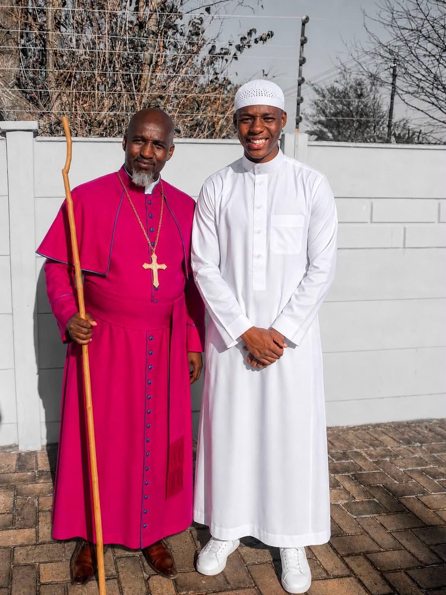 ubmeerat's tweet photo. “I was born in the Zion Church.

My father is a bishop, and for many years, that was the only path I knew. It was the faith of my parents, my grandparents, and my community.

But Allah, in His infinite mercy, guided me to Islam.

This picture tells the story of two journeys. My father standing in the faith he has known all his life, and me standing upon the faith that Allah guided me to.

A few days ago, my father did something that touched me deeply. He drove all the way to see me without telling me he was coming, simply to collect an English and isiZulu Qur’an that I had arranged for him as a birthday gift. I only realized he was there when he arrived.

As I handed him the Qur’an, I couldn’t help but reflect on the wisdom of Allah. I never imagined that one day I would be the first Muslim in my family, handing the Book of Allah to my own father.

I was the first in my family to hold the Qur’an. The first to say:

“La ilaha illallah, Muhammadur Rasulullah.”

Islam started with me in my family, but by the permission of Allah, I pray it does not end with me.”