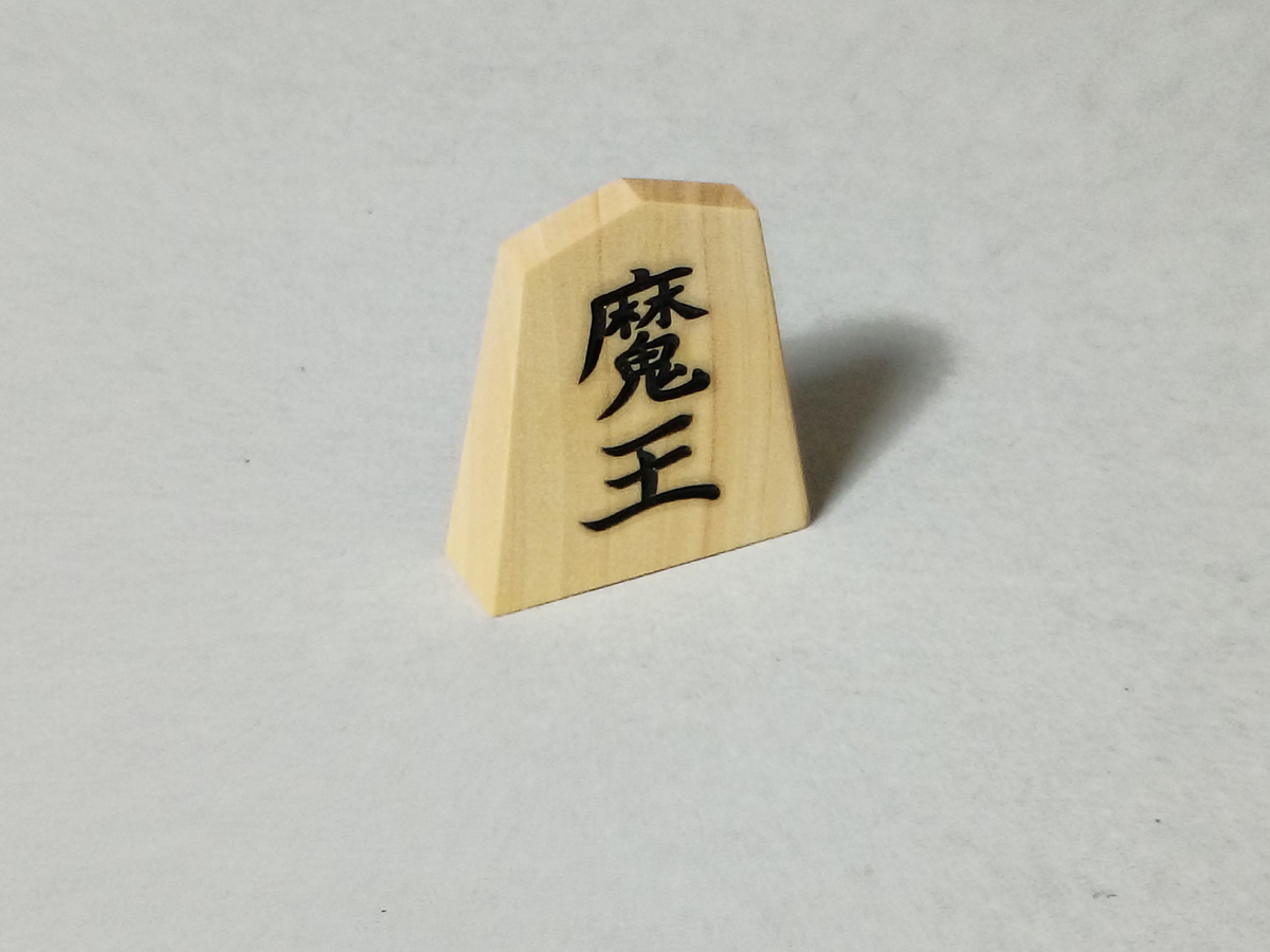 Cobatoshop's tweet photo. 【将棋の妄想】
子どもの頃将棋を指していても、高校や大学になってプロから学んでいる人には全く勝てなくなります…
となるともう異世界から駒を召喚するしかないとして、作ってみました「魔将」駒。
動き的には金将＋一歩。成ると「魔王」になります。
魔王の動きは王将＋一歩＆斜めだけ三歩。→ https://t.co/0xKqS7P8ZY