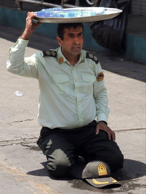 Servicecultu's tweet photo. Le jour des adieux à la dépouille du dirigeant iranien tombé en martyr, sous une chaleur accablante, un policier iranien distribue humblement de l'eau aux personnes présentes. Le monde a encore beaucoup à découvrir sur le peuple iranien.
#IranWar‌ #khamenei https://t.co/Dgv17vPz3I