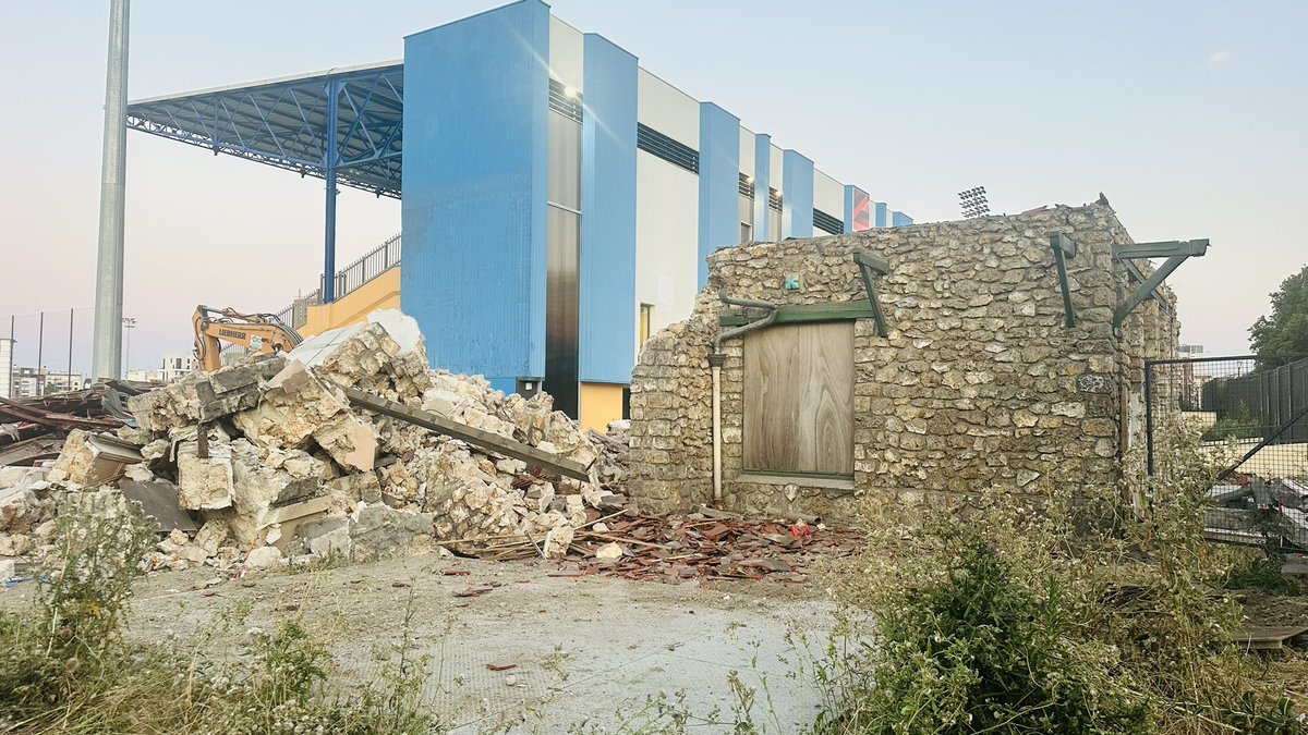 MoDemColombes's tweet photo. Un scandale depuis hier à #Colombes : la destruction dans la plus grande indifférence du pavillon de pesage du Stade Yves du Manoir. Ce bâtiment de l’ancien hippodrome datait de 1883.  Il a servi au pesage des jockeys jusqu’en 1907 et a été le restaurant bar du Racing Club à partir de 1913 jusqu’en 1990.
Retiré de l’annexe patrimoniale du PLU - comme l’octroi du Bd de Valmy - sa démolition était incluse dans la demande de permis de construire pour la rénovation du stade Yves du Manoir, accordée par la Ville de Colombes.