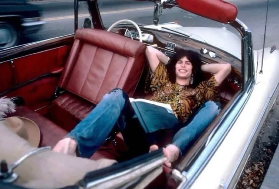 historyrock_'s tweet photo. Steven Tyler was photographed in his 1956 Mercedes Benz 220S at Jamaica Pond in Boston on October 9, 1975, capturing a glimpse of the rock star’s off stage life during the height of his career with Aerosmith.

 Known for his flamboyant stage presence, wide vocal range, and signature scarves, Tyler became one of the most recognizable figures in rock music, helping define the sound and style of hard rock from the 1970s onward.