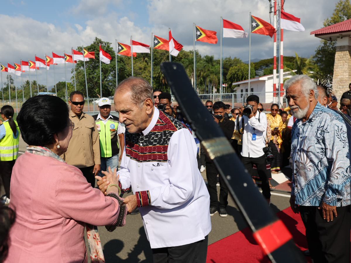 GunRomli's tweet photo. Ibu Megawati Soekarnoputri Tiba di Timor-Leste, Disambut Hangat Tokoh Penting dan Lambaian Bendera Anak Sekolah

Kunjungan ke Timor-Leste: Ibu Megawati Disambut Karpet Merah, Tarian Tradisional, hingga Antusiasme Pelajar

Mendarat di Dili, Ibu Megawati Soekarnoputri Terima Penyambutan Agung dari Pemerintah Timor-Leste

DILI – Presiden Kelima Republik Indonesia yang juga Ketua Umum PDI Perjuangan, Prof. DR. Megawati Soekarnoputri, melakukan kunjungan resmi ke Timor-Leste.

Menggunakan pesawat yang mendarat di Bandara Internasional Presidente Nicolau Lobato, Dili, rombongan Ibu Megawati tiba pada Rabu (8/7/2026), pukul 16.10 waktu setempat.

Begitu pesawat berhenti, Direktur Jenderal Urusan Protokol dari Kementerian Luar Negeri dan Kerja Sama Timor-Leste, Josefina Tilman, langsung naik ke pesawat untuk menyambut dan mendampingi Megawati turun menuju apron bandara.

Di kaki tangga pesawat, jajaran pejabat tinggi negara telah bersiap menyambut kedatangan beliau. Di antaranya adalah Wakil Perdana Menteri sekaligus Menteri Koordinator Bidang Perekonomian, Pariwisata, dan Lingkungan Hidup Timor-Leste, Francisco Kalbuadi Lay.

Turut hadir pula Kuasa Usaha Ad Interim (KUAI) Kedutaan Besar Republik Indonesia (KBRI) untuk Timor-Leste, Ibu Mardiana Warnares.

Prosesi penyambutan dilanjutkan dengan berjalan di atas karpet merah, di mana Ibu Megawati diapit oleh pasukan tradisional Moradores yang disiapkan oleh Kantor Penghubung Militer (Casa Militar) Kepresidenan Timor-Leste.

Ibu Megawati tiba didampingi keluarganya seperti Puti Guntur Soekarnoputri dan Romy Soekarno, serta jajaran partai seperti Sekretaris Jenderal PDI Perjuangan Hasto Kristiyanto dan Ketua DPP PDI Perjuangan Bintang Puspayoga.

Ibu Megawati lalu berjalan menuju sejumlah tokoh yang sudah lebih dulu bersiap untuk menerima kunjungannya. Termasuk Presiden Republik Timor-Leste, J. Ramos Horta, Perdana Menteri Rala Xanana Gusmão, Menteri Luar Negeri dan Kerja Sama Bendito dos Santos Freitas, dan Kepala Staf Kepresidenan Henriqueta M. da Silva.

Dari pihak Indonesia, sejumlah petinggi PDI Perjuangan seperti Ketua DPP PDIP yang juga Wakil Ketua Komisi XIII DPR-RI Andreas H. Pareira, Ketua DPP PDI Perjuangan bidang Luar Negeri Ahmad Basarah, Kepala Badan Riset dan Analisis Kebijakan Pusat Partai Andi Widjajanto, juga ikut dalam delegasi penyambutan.

Setelah bersalaman hangat dengan Ramos Horta, Xanana, dan pejabat Timor Leste lainnya, Ibu Megawati lalu disambut dengan tarian adat setempat. Ibu Megawati tampak menyapa para penari dengan senyuman manisnya.

Setelah itu, Ibu Megawati berjalan lagi dan dua orang gadis berpakaian adat setempat mempersembahkan buket bunga dan kain adat berwarna merah. Salah seorang anak perempuan kecil yang menyambutnya lalu mengalungkan kain itu.

Ibu Megawati lalu mengajak kedua anak perempuan itu berjalan bersama. Ia gandeng tangan kedua putri Timor itu di kanan san kirinya, dan berjalan bersama ke arah gedung kedatangan di bandara. Ramos Horta, Xanana, dan seluruh yang hadir menyambut, mengikuti di belakang.

Suasana hangat dan meriah tidak hanya terasa di dalam area bandara. Saat iring-iringan kendaraan Ibu Megawati Soekarnoputri mulai bergerak keluar dari kompleks Bandara Internasional Presidente Nicolau Lobato, ribuan anak sekolah telah bersiap di sepanjang jalan dari bandara menuju tempat penginapan.

Dengan penuh antusias, para pelajar tersebut mengibas-ngibaskan bendera kedua negara sebagai bentuk penghormatan dan sambutan hangat dari generasi muda Timor-Leste untuk menyambut kehadiran pemimpin perempuan pertama Indonesia tersebut.

Untuk diketahui, kunjungan kenegaraan Megawati ini akan berlangsung hingga 10 Juli 2026. Agenda utamanya adalah menerima penghargaan tertinggi Grand Collar of Timor Leste atas jasanya dalam memajukan hubungan bilateral dan rekonsiliasi kedua negara dari Presiden Jose Ramos-Horta...