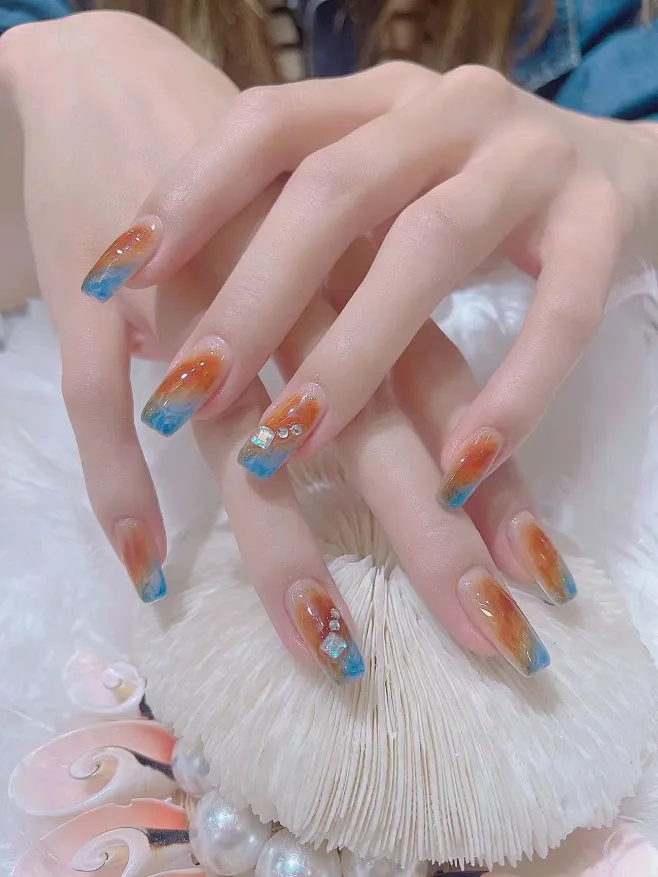 Biutee_jp's tweet photo. 琥珀のようなシアーオレンジと深みのあるブルーのコントラストが夏らしくて最高🥰🤍＃biutee #ニュアンスネイル #夏ネイル https://t.co/4EZzN6UNef