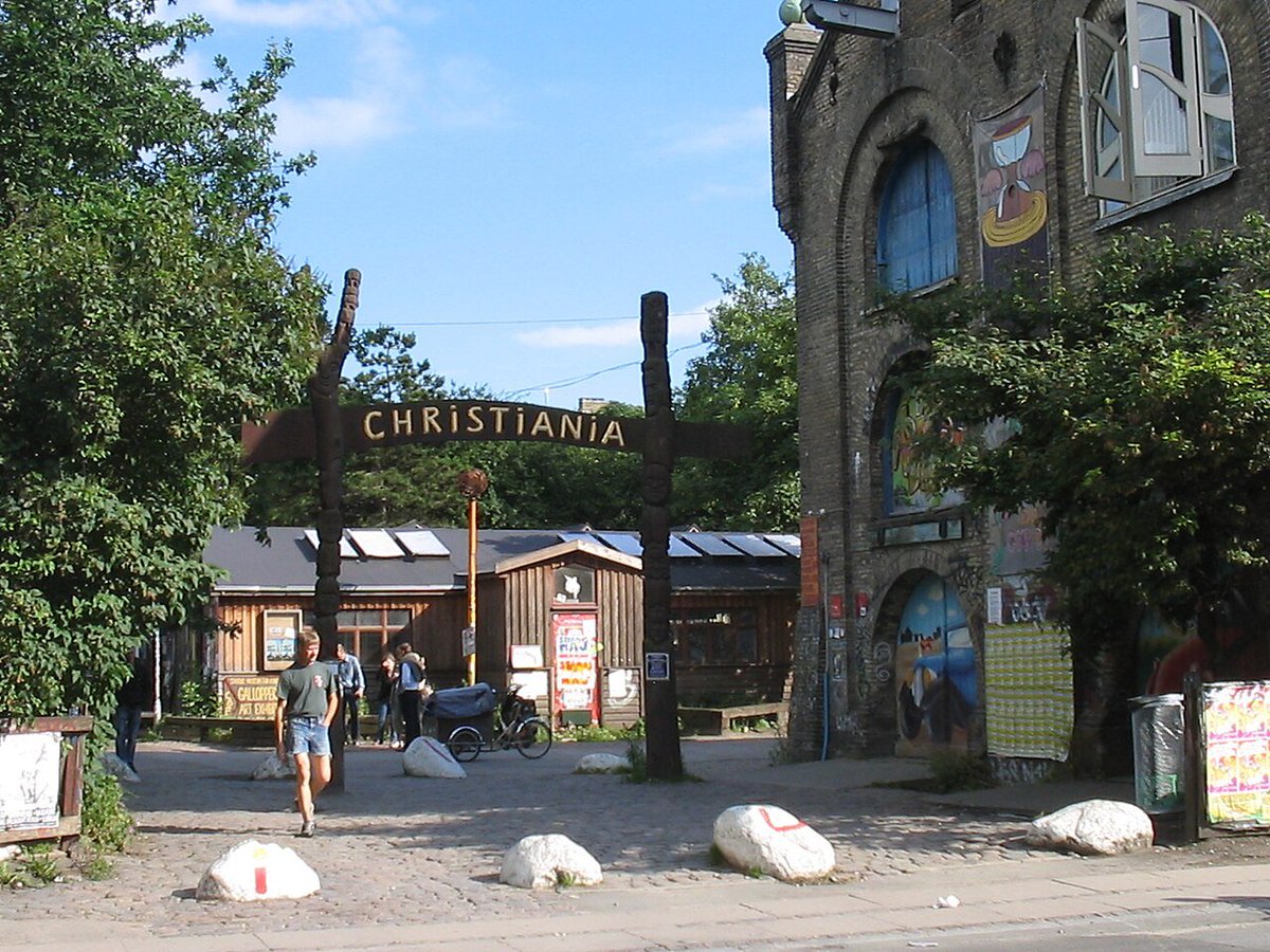 RedHotWorld's tweet photo. In 1971, Copenhageners cut a hole in a fence and turned an abandoned military barracks into a self-governing town. You don't buy a home there, you apply, and if the community agrees, it's yours.

55 years on, Freetown Christiania is still going strong - but no photos are allowed. https://t.co/6wBGVm0L6k