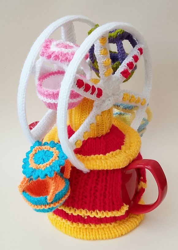 TeaCosyFolk's tweet photo. The Big Wheel Tea Cosy is a lively, nostalgic design that captures the fun of a classic fairground ride. A standout knit for anyone who loves funfairs. https://t.co/YFj0b2GUuF #knit #TeaCosyFolk #bigwheel #fairground #nostalgiaknits #giftideas #knittingpattern https://t.co/VFJB7PGP78