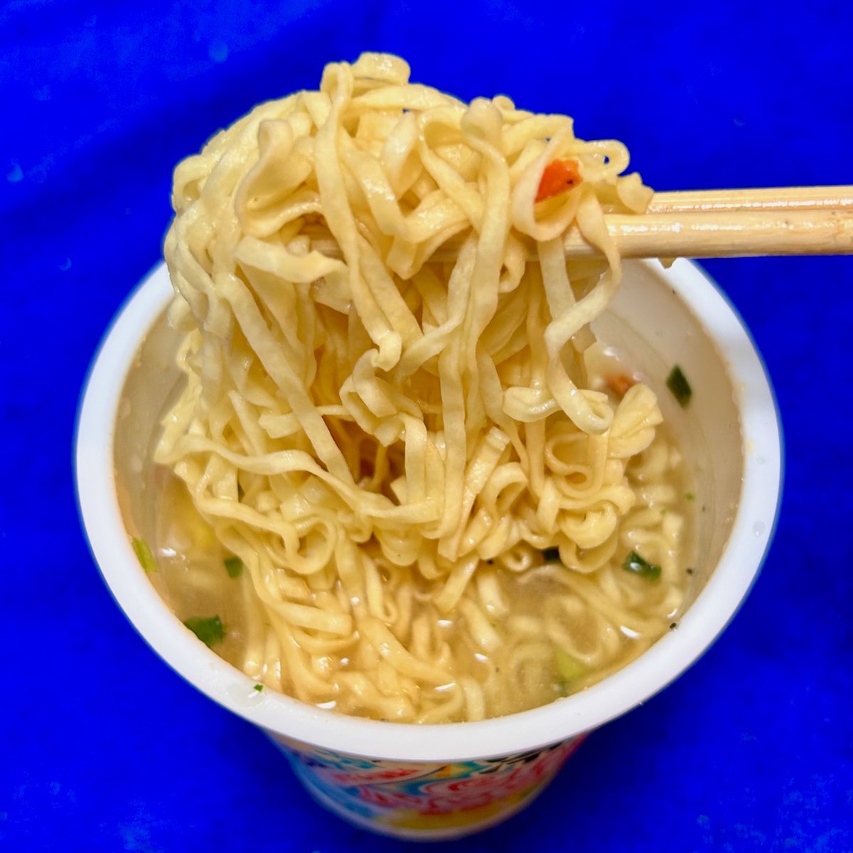 oosaki1959's tweet photo. 7月20日発売の「冷しカップヌードル」実食！

20日に買おうと思ってコンビニ2軒回ったが売ってない。昨日も違う場所で2軒行ったのに売ってない。今日、ようやく購入。（セブン）
熱湯ではなく“冷水5分”というところがポイント。これまでも「どん兵衛にお湯の代わりに水を注ぎ、約15〜25分待って食べてみた」という投稿などもバズり、水でも食べられることは知られていたが、今回の商品は“熱湯禁止”で『冷水専用』のカップ麺。カップヌードル発売55年目で史上初。

2種類の味が発売されており、私が食べたのは「鶏塩レモン味」。（他には「ピリ辛キムチ味」）
冷水を入れて“蓋をして”（蓋をする必要があるのかは不明（笑））5分待つ。
私は、基本的に“麺上げ（麺リフト）”写真は撮らないが、今回は麺のほぐれ具合を見てもらうためにあえて撮りました。よく混ぜたのですが、ちょっとだけ絡まっていました。でも、それが気にならないくらいに“戻って”ますね。思った以上においしい。レモンの酸味が清涼感あり、鶏・鰹・煮干しのスープはさっぱりしてゴクゴク飲める。ただ、全体的に量が少ない。二個食べておにぎりも欲しいかな（笑）。ちょっと比較してみました。

カップヌードル通常サイズ：総重量 77g（うち麺量 60g）価格248円（税別）
冷しカップヌードル：総重量 59〜60g（うち麺量 45g）価格285円（税別）

総重量比78％、価格比115％。まあ〜当初は開発費がここに乗ってくるだろうし、しょうがないかな。すでにもう一個買ってあるし、また追加で買うかも。この夏の暑さには耐えられません。明日から、35度を超える日の昼飯は抜くことにしました。とにかく、外を出歩くのが私の年齢だと命がけ。冷やしカップ麺、この夏は重宝させていただきます。