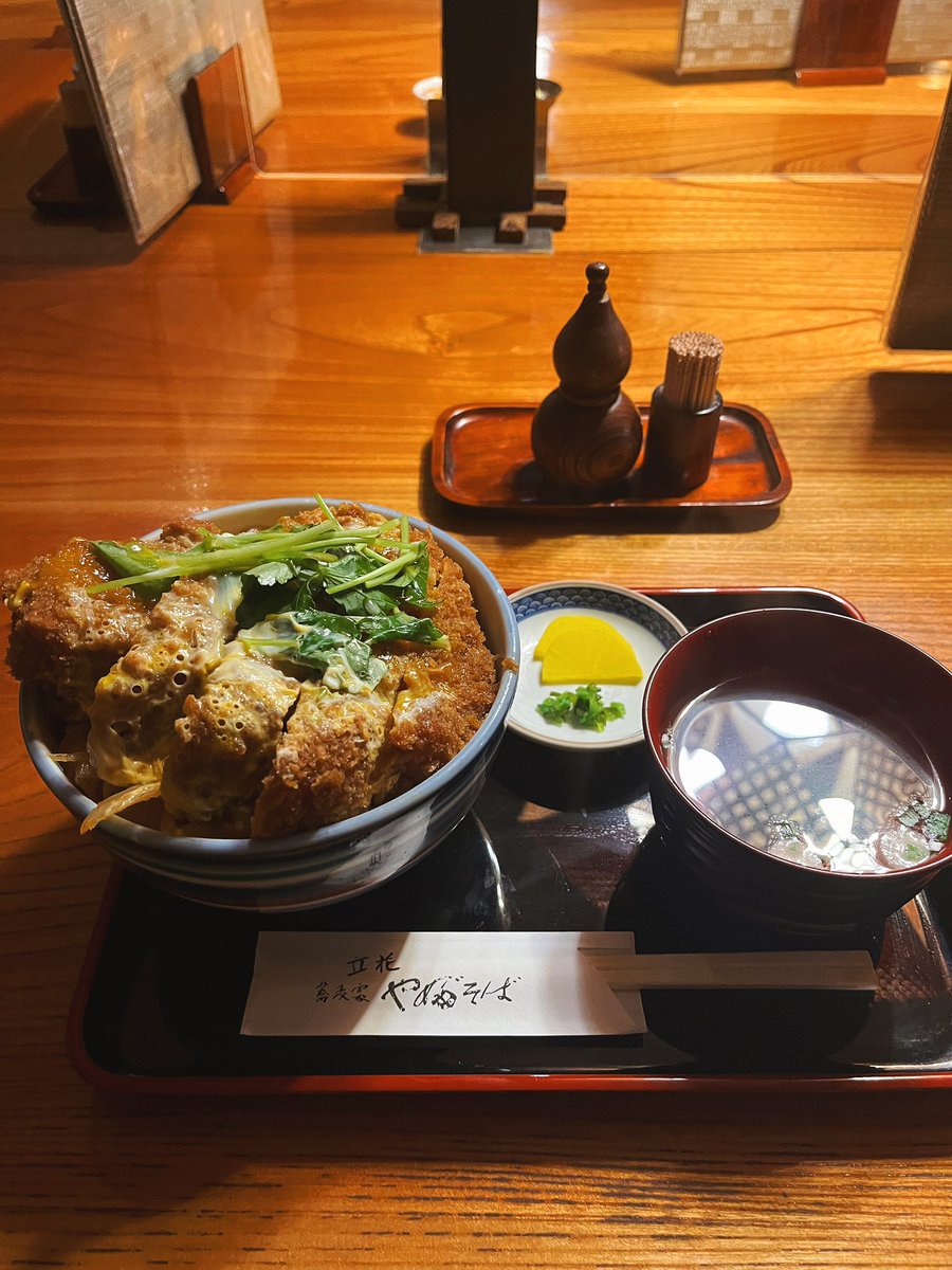 selfcomestomine's tweet photo. カツ丼ジュクジュク問題。

最近は「とじないカツ丼」がブームだ。せっかく揚げたカツのサクサク感を守るべきだ、という思想である。

その気持ちはわかる。前にも書いたように、人類は祖先の時代から、「サクッ」「カリッ」という食感を、《新鮮で安全な食物発見！！》のサインとして扱うように進化してきた。自然界で腐ったものはヌチャッとしているのだから、サクサクを愛するのは生物学的には合理的だ。

しかし、それでも俺はジュクジュク派である。

なぜなら、カツ丼のうまさはフライではなく、エンジニアード・フレーバーに本質があるからだ。

揚げたてのカツをあえて割り下へ沈める。この時、衣はサクサクを守る鎧ではなく、出汁を吸い込むスポンジへと姿を変える。そこへ肉汁、甘辛いタレ、しみしみのタマネギ、半熟卵のコクが染み込み、最後に白米まで巻き込んで、一口の中で一つの料理として完成する。

カツ丼のうまさを作り出しているのは、これらの味がジュクジュクに融合して染みた衣なのだ。

サクサク派は、おそらくカツ単体を評価している。フライを好む本能が水分による濡れ＝腐敗リスクを本能的に許さない。だがジュクジュク派が評価しているのは、複数の食材が融合した、味覚的一体感だ。

人類は焚き火で調理を始めて以来、さまざまな食材を混ぜ、加熱し、自然界には存在しない味を"設計"する動物になった。これがエンジニアード・フレーバーだ。

この「味の設計」~要はグルメ〜の追求こそ、人類の狩猟活動拡大───そして大量絶滅の発生───の原動力だったと論じる研究者すらいる。* Dunn, R. R., & Sanchez, M. (2021). 

さてここでいう「フレーバー／flavor」とは、たんなる「味／taste」ではない。

オックスフォード大の実験心理学者チャールズ·スペンスは、フレーバーとは舌で感じる味覚だけでなく、香り、食感、温度、音（サクサク音など）、さらには見た目までが脳内で〈統合〉されて初めて生まれる知覚体験だと論じている。
*Spence, C. (2015)

カツ丼においては、ジュクジュクに出汁を吸った衣こそが、この〈統合〉を可能にしているのだ。

だから「サクサクが失われるからダメ」という奴らは、カツ丼のうまさの本質を見誤っている。サクサクを捨てているんじゃない。サクサクという報酬を少しだけ差し出し、その代わりに味の統合性と一体感という、もっと大きな報酬を受け取っているのだ。

とじないカツ丼派は、ただ揚げ物を食べている。

ジュクジュク派は、カツ丼を食べているのである。

📍やぶそば立花（墨田区東あずま）

#進化グルメ学