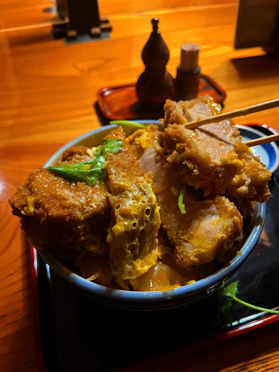 selfcomestomine's tweet photo. カツ丼ジュクジュク問題。

最近は「とじないカツ丼」がブームだ。せっかく揚げたカツのサクサク感を守るべきだ、という思想である。

その気持ちはわかる。前にも書いたように、人類は祖先の時代から、「サクッ」「カリッ」という食感を、《新鮮で安全な食物発見！！》のサインとして扱うように進化してきた。自然界で腐ったものはヌチャッとしているのだから、サクサクを愛するのは生物学的には合理的だ。

しかし、それでも俺はジュクジュク派である。

なぜなら、カツ丼のうまさはフライではなく、エンジニアード・フレーバーに本質があるからだ。

揚げたてのカツをあえて割り下へ沈める。この時、衣はサクサクを守る鎧ではなく、出汁を吸い込むスポンジへと姿を変える。そこへ肉汁、甘辛いタレ、しみしみのタマネギ、半熟卵のコクが染み込み、最後に白米まで巻き込んで、一口の中で一つの料理として完成する。

カツ丼のうまさを作り出しているのは、これらの味がジュクジュクに融合して染みた衣なのだ。

サクサク派は、おそらくカツ単体を評価している。フライを好む本能が水分による濡れ＝腐敗リスクを本能的に許さない。だがジュクジュク派が評価しているのは、複数の食材が融合した、味覚的一体感だ。

人類は焚き火で調理を始めて以来、さまざまな食材を混ぜ、加熱し、自然界には存在しない味を"設計"する動物になった。これがエンジニアード・フレーバーだ。

この「味の設計」~要はグルメ〜の追求こそ、人類の狩猟活動拡大───そして大量絶滅の発生───の原動力だったと論じる研究者すらいる。* Dunn, R. R., & Sanchez, M. (2021). 

さてここでいう「フレーバー／flavor」とは、たんなる「味／taste」ではない。

オックスフォード大の実験心理学者チャールズ·スペンスは、フレーバーとは舌で感じる味覚だけでなく、香り、食感、温度、音（サクサク音など）、さらには見た目までが脳内で〈統合〉されて初めて生まれる知覚体験だと論じている。
*Spence, C. (2015)

カツ丼においては、ジュクジュクに出汁を吸った衣こそが、この〈統合〉を可能にしているのだ。

だから「サクサクが失われるからダメ」という奴らは、カツ丼のうまさの本質を見誤っている。サクサクを捨てているんじゃない。サクサクという報酬を少しだけ差し出し、その代わりに味の統合性と一体感という、もっと大きな報酬を受け取っているのだ。

とじないカツ丼派は、ただ揚げ物を食べている。

ジュクジュク派は、カツ丼を食べているのである。

📍やぶそば立花（墨田区東あずま）

#進化グルメ学