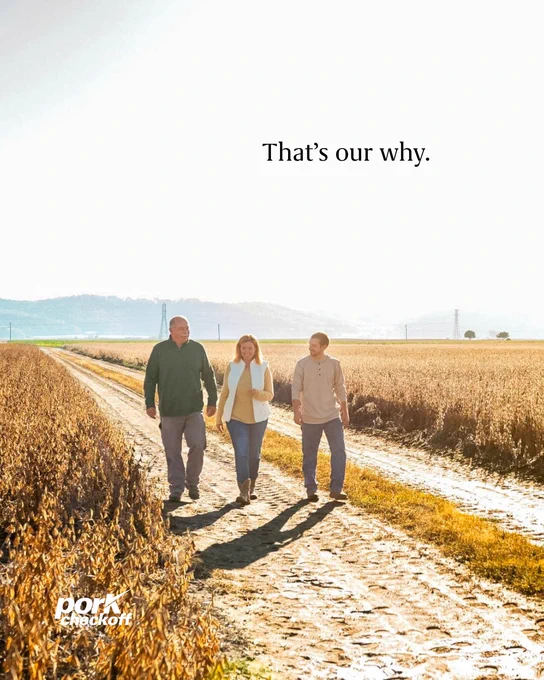 Three people walking on a dirt path through a vast field of tall crops under a bright sky. The text reads "Thatโs our why."