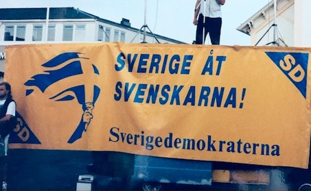 SwedishHistoryX's tweet photo. 📷 En ung Jimmie Åkesson, nuvarande partiledare för SD, på ett torgmöte i Sölvesborg, hållandes i en banderoll med parollen "Sverige åt Svenskarna!".   

Samma slogan har används av nationella rörelsen sedan 1920-talet.    

📍1995, Blekinge https://t.co/0VZqsGp9Ln