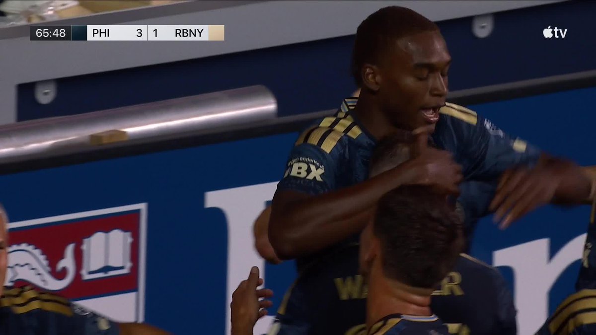 Philadelphia Union player Neil Pierre, an 18-year-old standing 6'7", is lifted in celebration by a teammate after scoring, with the scoreboard showing PHI leading RBNY 3-1 at the 65:48 mark during an MLS match on Apple TV.