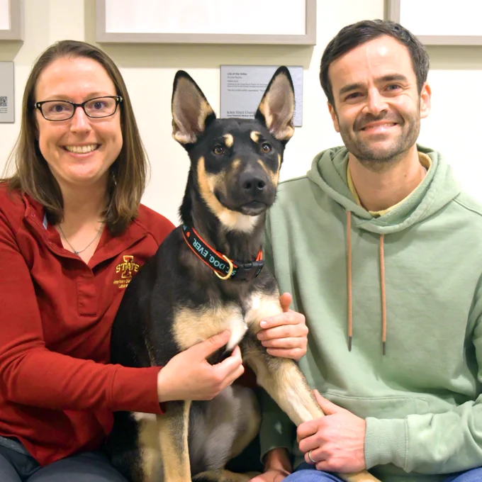 Laura (’10, ’13) and Matt (’08) Bradner smile as they pose with Honey.  
