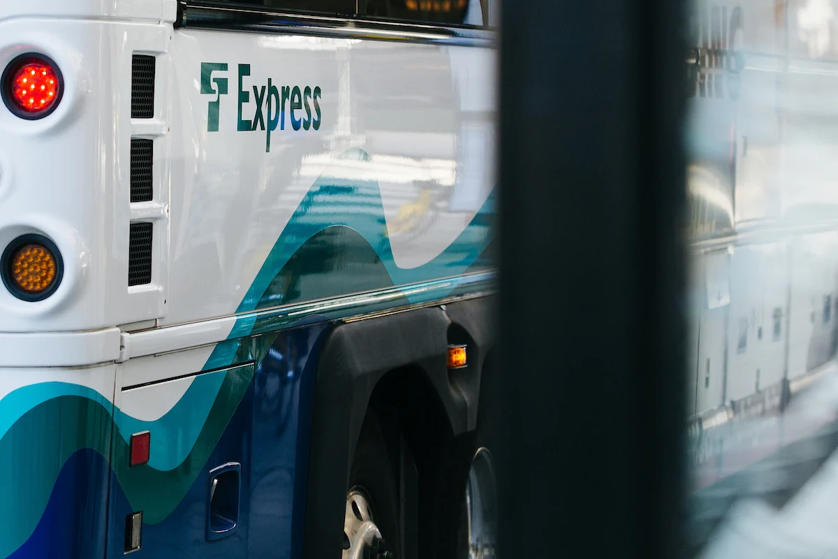 A bus with "ST Express" written on the side is parked. The side of the bus features a wavy blue and green design.