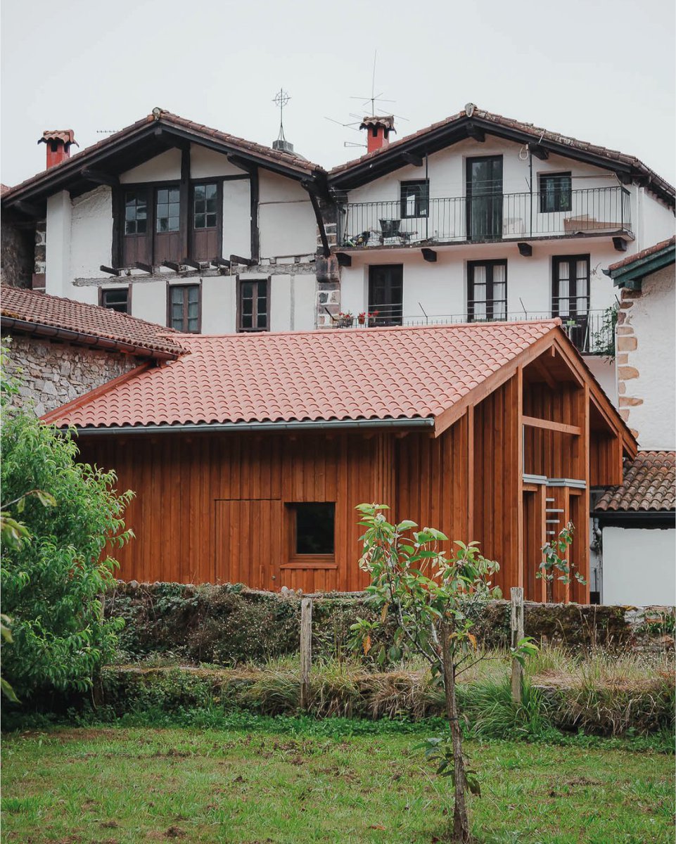 Hispalyt's tweet photo. La rehabilitación del conjunto Itzalbaita en Bera (Navarra) firmada por Mugara Arkitektura fue inscrita en la categoría de Rehabilitación en el Premio de Arquitectura de Teja de Hispalyt 2023-2025, y resultó seleccionada para la web. Itzalbaita es la suma de un edificio de piedra, el porche de madera adosado y el jardín, delimitado al norte por el río Zia que baja desde la casa de los Baroja, pocos metros más arriba.

La estructura de madera del porche se encontraba extremadamente deteriorada debido a la carcoma, por lo que se hace necesaria su restitución manteniendo el esquema estructural y volumetría de la cubierta original. Se trata de un volumen adosado al edificio de piedra, cuya cubierta tradicional de teja a dos aguas y sus grandes aleros lo protegen de las abundantes lluvias que caracterizan este clima. El cerramiento se ejecuta a base de tablero de madera alerce, dando continuidad así a la materialidad de la pieza existente.

🏠 @TejasBorja 
📸 Aitor Estévez Olaizola

Así fue el Acto de Entrega de los Premios de Arquitectura de Hispalyt, celebrado el pasado 4 de junio en La Casa de la Arquitectura. Si quieres volver a ver la ceremonia o verla por primera vez, ya tienes el vídeo disponible en nuestro canal de YouTube: https://t.co/Wp6pTAYs2I

Las obras ganadoras ya están disponibles en la web de los Premios de Arquitectura de Hispalyt. Entra y descubre todos los proyectos: https://t.co/loinK06sMx 👏

#juevesdearquitectura #PremiosArquitecturaHispalyt2025