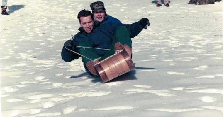 spymain123's tweet photo. An archival photograph capturing a lighter moment at Camp David in January 1991, featuring Arnold Schwarzenegger and President George H.W. Bush sledding together during an official weekend retreat. https://t.co/WqaM4JWp3Y