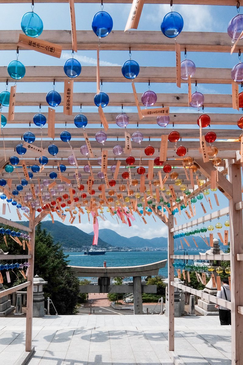 海を渡る風と、涼やかな音色。 鳥居の向こうに広がる青い海と、鮮やか