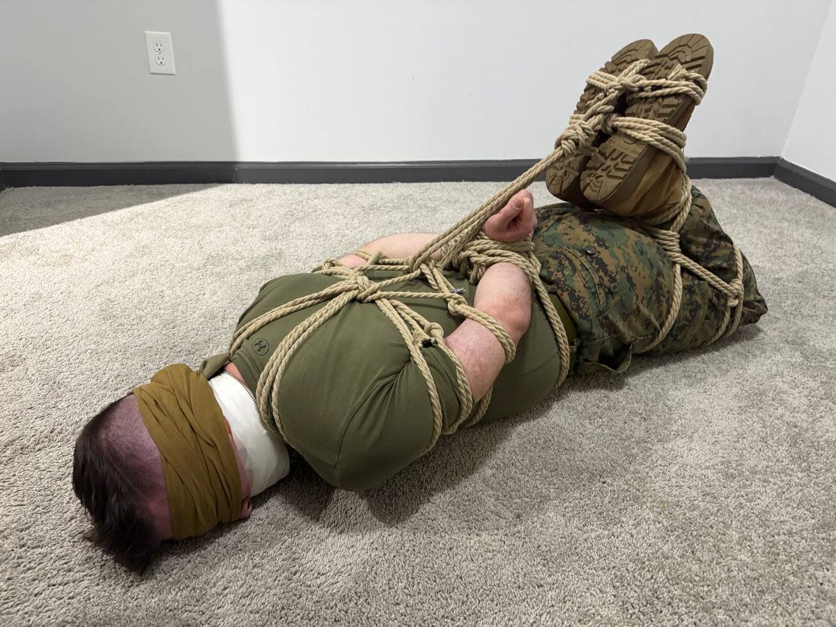 ThatBondageguy's tweet photo. @uniformdistress convinced me to try to get out of a hogtie next. I say "convinced" but it was more like "volun-told". I should have taken the opportunity to take the tape off and pull the sock out of my mouth while my hands were free https://t.co/LZMQxx3X2P