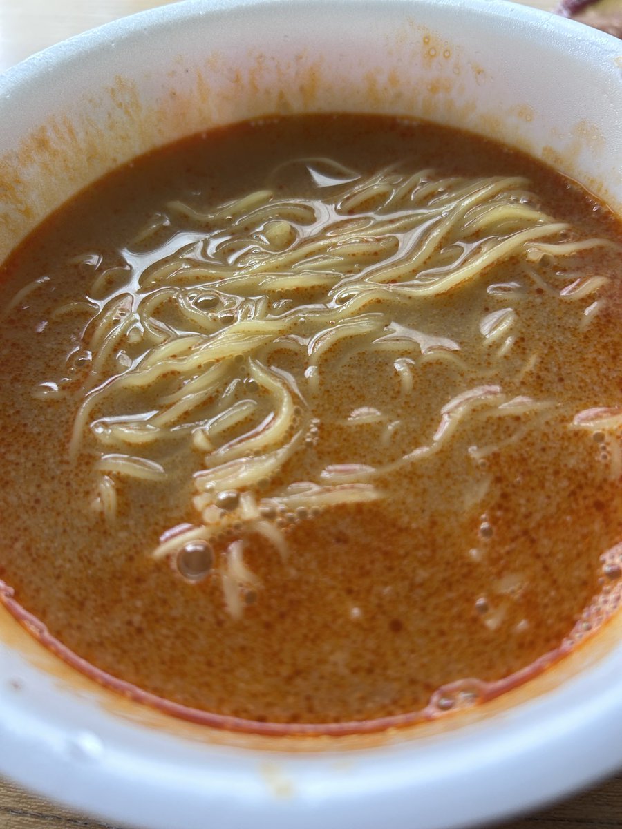 DreamyCat_Miyu's tweet photo. 濃いは「旨い」なのか？

ローソン【スープ激うま！濃厚担々味ラーメン】

美味しいかどうかでいったら間違いなく美味しい。ありえないほど旨いと思った。
だがしかし、何かひっかかるものを感じる、何故なのか？

カップ麺研究家taka: aさんも絶賛のこちら、私も食べたのでレビューしていきます。
これ、担々麺ではないというところに注目したい、あくまでも坦々味なのだ。
まぁどうでもいい感じはするけど、担々麺界隈に殴り込むつもりはないらしいことが伺えるｗ

さて各所大絶賛されている本商品、私もやはりひと口目で正直驚きました。こんな旨い坦々味ラーメン、過去にあったかな・・・いや無い。

スープは粉末ではなく、ひとつは液状のもの、もうひとつはいわゆる胡麻ペーストって言って良いだろう。どちらから入れたものかとやや悩ましいけど、私は液状のほうを先に入れ、よく混ぜてから胡麻ペーストを入れました。おそらくそんなに間違ってはいないと思うので参考にされたし。
昨今流行りの具材の無いパターンですが、値段が安いわけではなくスープに特化した構成ゆえの238円。安過ぎず高過ぎずのちょうど真ん中な印象です。
麺はこの種の坦々系カップ麺ではおなじみの細麺です。これ旨いんですよね～。

辛さとしては警戒するような辛さではないんですが、ひと口目で喉に直撃するような刺激があるのでそこだけは注意が必要です。私も「お゛っ♡♡」って声出かけましたｗ

本商品、表記通り実に濃厚な仕上がりとなっていて、濃い目が好き、しょっぱめが好きな人にはぶっ刺さる濃厚具合だと感じました。そしてそれはあきらかに旨い。
成分表記を見ると、練りごま、しょうゆ、豚脂、ポークエキスが上位です。したがって味の骨格は、ごまの油脂感＋豚骨系のコク＋しょうゆのキレ。これが「坦々味」と表記する理由なのかもしれないですね。
日本式のよくある担々麺であれば味噌ベースが一般的だと思います。
あきらかに旨いんですよ、スープだけで「旨い！」って言わせるぞっていう意地のようなものを感じる。
そしてそれは私の舌にも見事に直撃しました、驚くほど旨いです。美味しいです。

これが絶賛されるのも容易に頷ける。これで首をかしげる人なんているんだろうかって考えた時に、ちょっと「あれ？」と思う部分に気づき始めたんです。

本商品、本当にめちゃくちゃ濃厚で、かなり濃い口で、しょっぱいの大好き田舎民にぶっ刺さる気がします。しかし一方で、しょっぱいもの好きの私でさえ「うわ～濃いなぁ！」と感じたということ、無視してはいけない気がしました。はっきり明確に感じる旨味、濃厚さ、塩分的なしょっぱさ。
果たして「濃いは旨い」なのか？早死に三段活用で慣れてしまっていると、うっかりこの疑問を見逃してしまいそうになる。見方を少し捻ると、すごく濃いスープと麺だけなんだという事実。旨いがしかし、食べ手によっては「旨い」よりも「濃いな」「しょっぱいな」が先に感想として浮かび上がってくる、その可能性もまた否めない。
この濃厚さの中に複雑な旨味、味わい、そして楽しさが、果たして詰まっているのだろうか。そう考えた時、私の感想は「すごく濃い坦々スープ」の域を出なかったのだ。もちろんそれが田舎者の味覚に直撃するのはわかっているつもりだし、実際間違いなく旨い。しかしながら、スープで勝負するカップ麺としては、単調でシンプルで、担々麺スープが濃くなっただけのような、何か決め手を欠いている気がしてならない。

具材があれば解決していたのかどうか、正直自信はないけれど、坦々味と表記していることから、麺づくりよろしく薄っぺらい叉焼が入っていても良さそうだったし、緑の要素があっても良かったように感じる。何かしらあれば、濃いは旨いなのか否か、という疑問はそもそも出てこなかったかもしれない。

評価：Ａ＋

ものすごく美味しいスープだったがしかし、手放しに褒めちぎるのは何かが足りない。かといって申し訳程度にネギがパヤパヤ浮いているだけでは、それはおそらくだめだろう。昨今具材を抜くカップ麺があとを絶たないが、それゆえにせっかくここまでこだわっているのにあと一歩何かが足りない！というケースが多い気がして歯がゆい。
具材が無くても「いや、無くていいんだ、これで良いんだ」と納得させられる商品だって確かにあったじゃないかと。
現状は何か重要なピースがあとひとつ足りない未完成のパズルのような状態だと言えよう。