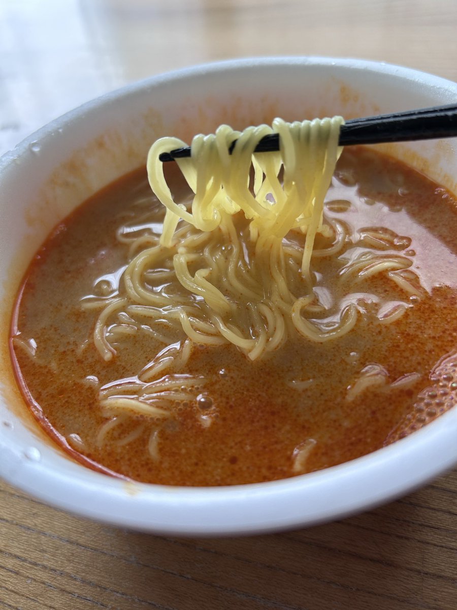 DreamyCat_Miyu's tweet photo. 濃いは「旨い」なのか？

ローソン【スープ激うま！濃厚担々味ラーメン】

美味しいかどうかでいったら間違いなく美味しい。ありえないほど旨いと思った。
だがしかし、何かひっかかるものを感じる、何故なのか？

カップ麺研究家taka: aさんも絶賛のこちら、私も食べたのでレビューしていきます。
これ、担々麺ではないというところに注目したい、あくまでも坦々味なのだ。
まぁどうでもいい感じはするけど、担々麺界隈に殴り込むつもりはないらしいことが伺えるｗ

さて各所大絶賛されている本商品、私もやはりひと口目で正直驚きました。こんな旨い坦々味ラーメン、過去にあったかな・・・いや無い。

スープは粉末ではなく、ひとつは液状のもの、もうひとつはいわゆる胡麻ペーストって言って良いだろう。どちらから入れたものかとやや悩ましいけど、私は液状のほうを先に入れ、よく混ぜてから胡麻ペーストを入れました。おそらくそんなに間違ってはいないと思うので参考にされたし。
昨今流行りの具材の無いパターンですが、値段が安いわけではなくスープに特化した構成ゆえの238円。安過ぎず高過ぎずのちょうど真ん中な印象です。
麺はこの種の坦々系カップ麺ではおなじみの細麺です。これ旨いんですよね～。

辛さとしては警戒するような辛さではないんですが、ひと口目で喉に直撃するような刺激があるのでそこだけは注意が必要です。私も「お゛っ♡♡」って声出かけましたｗ

本商品、表記通り実に濃厚な仕上がりとなっていて、濃い目が好き、しょっぱめが好きな人にはぶっ刺さる濃厚具合だと感じました。そしてそれはあきらかに旨い。
成分表記を見ると、練りごま、しょうゆ、豚脂、ポークエキスが上位です。したがって味の骨格は、ごまの油脂感＋豚骨系のコク＋しょうゆのキレ。これが「坦々味」と表記する理由なのかもしれないですね。
日本式のよくある担々麺であれば味噌ベースが一般的だと思います。
あきらかに旨いんですよ、スープだけで「旨い！」って言わせるぞっていう意地のようなものを感じる。
そしてそれは私の舌にも見事に直撃しました、驚くほど旨いです。美味しいです。

これが絶賛されるのも容易に頷ける。これで首をかしげる人なんているんだろうかって考えた時に、ちょっと「あれ？」と思う部分に気づき始めたんです。

本商品、本当にめちゃくちゃ濃厚で、かなり濃い口で、しょっぱいの大好き田舎民にぶっ刺さる気がします。しかし一方で、しょっぱいもの好きの私でさえ「うわ～濃いなぁ！」と感じたということ、無視してはいけない気がしました。はっきり明確に感じる旨味、濃厚さ、塩分的なしょっぱさ。
果たして「濃いは旨い」なのか？早死に三段活用で慣れてしまっていると、うっかりこの疑問を見逃してしまいそうになる。見方を少し捻ると、すごく濃いスープと麺だけなんだという事実。旨いがしかし、食べ手によっては「旨い」よりも「濃いな」「しょっぱいな」が先に感想として浮かび上がってくる、その可能性もまた否めない。
この濃厚さの中に複雑な旨味、味わい、そして楽しさが、果たして詰まっているのだろうか。そう考えた時、私の感想は「すごく濃い坦々スープ」の域を出なかったのだ。もちろんそれが田舎者の味覚に直撃するのはわかっているつもりだし、実際間違いなく旨い。しかしながら、スープで勝負するカップ麺としては、単調でシンプルで、担々麺スープが濃くなっただけのような、何か決め手を欠いている気がしてならない。

具材があれば解決していたのかどうか、正直自信はないけれど、坦々味と表記していることから、麺づくりよろしく薄っぺらい叉焼が入っていても良さそうだったし、緑の要素があっても良かったように感じる。何かしらあれば、濃いは旨いなのか否か、という疑問はそもそも出てこなかったかもしれない。

評価：Ａ＋

ものすごく美味しいスープだったがしかし、手放しに褒めちぎるのは何かが足りない。かといって申し訳程度にネギがパヤパヤ浮いているだけでは、それはおそらくだめだろう。昨今具材を抜くカップ麺があとを絶たないが、それゆえにせっかくここまでこだわっているのにあと一歩何かが足りない！というケースが多い気がして歯がゆい。
具材が無くても「いや、無くていいんだ、これで良いんだ」と納得させられる商品だって確かにあったじゃないかと。
現状は何か重要なピースがあとひとつ足りない未完成のパズルのような状態だと言えよう。