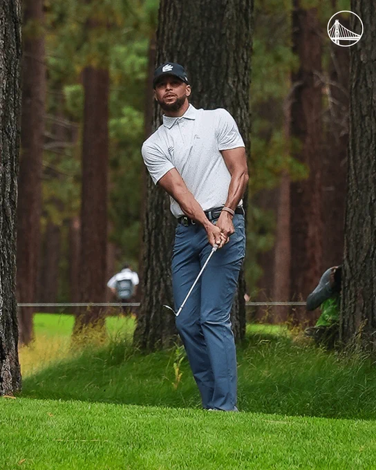 Stephen Curry drives a ball while playing golf
