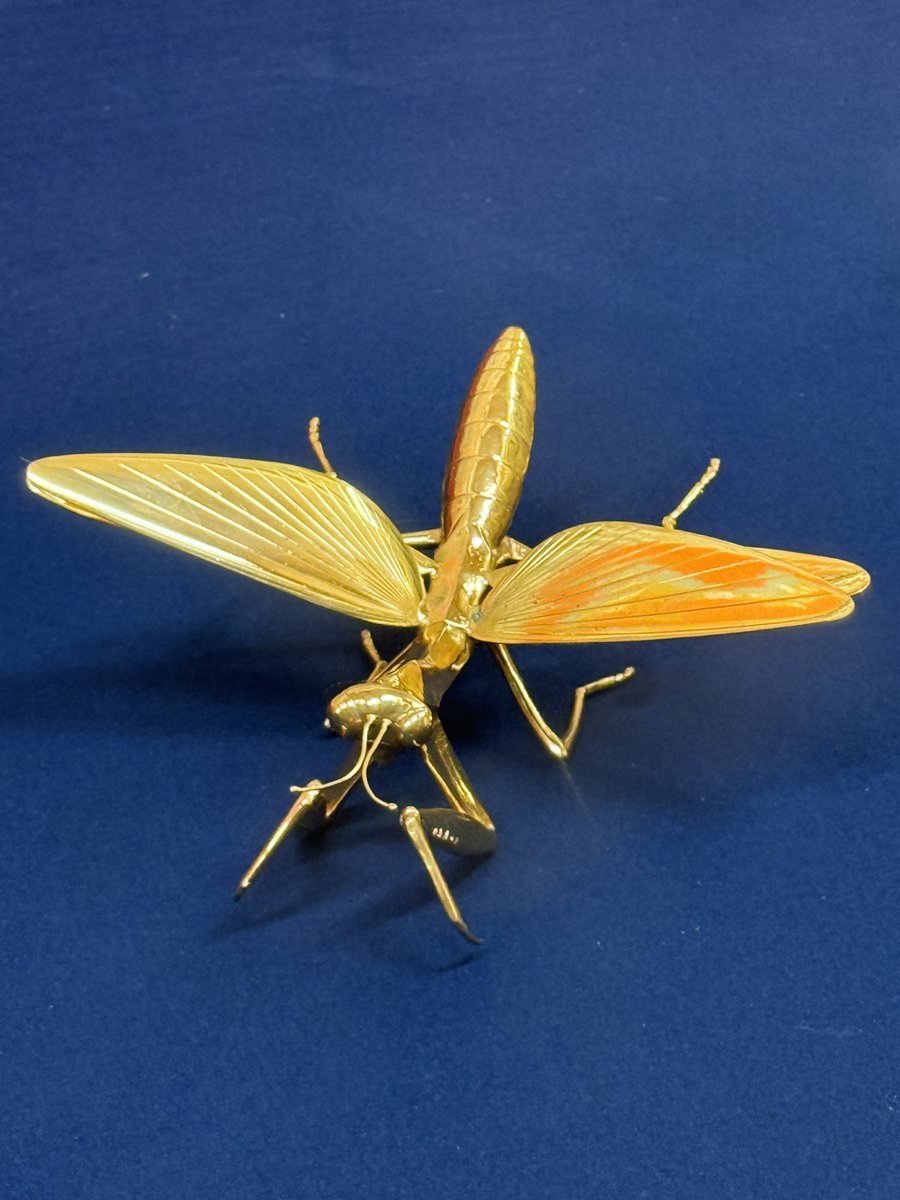 蟷螂山の金のカマキリを横でイタリアの方が不思議そうに眺めている。