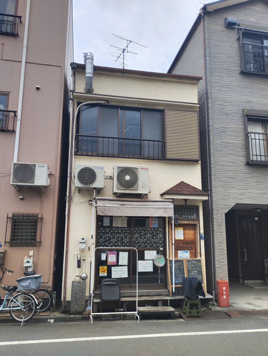 key__yacht's tweet photo. カレーに溶け込んだ生薬、華麗に溶け込んだ外観。

𖡼.𖤣𖥧𖡼.𖤣𖥧𖡼.𖤣𖥧𖡼.𖤣𖥧𖡼.𖤣𖥧𖡼.𖤣𖥧𖡼.𖤣𖥧𖡼

店外に置かれた黒板には、「薬膳カレー」と大きく謳っており、「茯苓、党参、決明子、乾姜、蒲公英、甘草、薏苡仁」と使っている生薬が羅列。

また、梅雨対策であることを強調し、
「体にたまった余分な“湿”は、むくみ、めまい、だるさ、食欲不振など、様々な不調を引き起こします。“水”の巡りを助け体内の水分バランスを整える生薬を配合しました」と今回選んだ生薬の理由を言語化している。

黒板の文字が手書きであることは、毎日のように生薬を替えているということでもあるだろう。
見識が深いことを感じさせ、否が応でもカレーの味に期待が高まる。

𖡼.𖤣𖥧𖡼.𖤣𖥧𖡼.𖤣𖥧𖡼.𖤣𖥧𖡼.𖤣𖥧𖡼.𖤣𖥧𖡼.𖤣𖥧𖡼

カレー３種　　1450
・チキンと茄子のウプカリ
・刻んだ野菜と薬味のキーマ
・タラとキノコのガーリックモイリー
・紫キャベツと銀耳のアチャール
・大根と玖魂花のオリーブオイル和え
・生姜と人参のラペ
・玉ねぎとハイビスカスのピクルス

𖡼.𖤣𖥧𖡼.𖤣𖥧𖡼.𖤣𖥧𖡼.𖤣𖥧𖡼.𖤣𖥧𖡼.𖤣𖥧𖡼.𖤣𖥧𖡼，

カレーと期待を乗せたスプーン。
握る手に力が入る。

出汁の旨味を活かした南インド風のウプカリ、ココナッツにニンニクが効いているガーリックモイリーはいずれもスープ状。それに加えキーマカレーも楽しめるのは嬉しい。

それぞれ違うカレーを口に入れては、アチャール、オリーブオイル和え、ラペ、ピクルスと多彩な副菜も後を追う。

複雑なスパイスは適度な辛さをまとい、副菜の様々な味と絡み合う。副菜は酸味が特徴的で、種類により差異があるため飽きが来ない。

スプーンを持つ手が止まらない…！

だが、その瞬間が来た。

スプーンが空を切る。

そう、ごはんがなくなったのだ。

「ごはんを単品で追加できますか？」

良くあることなのだろうか。店員は即座に答える。

「大盛で頼んでいないので、その分を追加いたしますね」

だが、これが僥倖となる。

追加のごはんとなったため、新しい器に盛られて来たのだが、これが平皿ではなく深��できたのだ。

残ったカレーや副菜を全て混ぜ入れることを容易にさせる…！
特にスープ状のカレーの防波堤としては最適だ。
最初から大盛にしていたのではこうはうまくはいかなかったであろう、とほくそ笑む。

全てを混ぜ入れて口に放り込む。

これぞまさに大団円。

有終の美として、きらびやかに口内を旨味が躍動��る。

グイと水をひと飲み。

レモンとミントが入った冷えた水は、爽やかさの極致！
シンプルさが複雑に絡み合った旨味を涼しげに美しい思い出へと追いやる。

「ごちそうさまでした」

外に出て改めて店を見ると、民家群と民家群の間に店。
可視化するならば、「家家家店家家家」といったところ。

見事に華麗に溶け込んでいる。

外壁に張り付いた室外機によって民家が民家であるための生活感を演出しているためだろうか。周囲に溶け込んでいるのだ。

「民家」にささやかに抵抗しているかのようにも見える、一部お洒落な外観がなければ、平然と通り過ぎていただろう。

京成曳舟駅が最寄りとなる住宅街に、間違い探しのように店舗を構えるカレー屋「サハスラーラ」。
食してみると、その味に間違いはなかった。