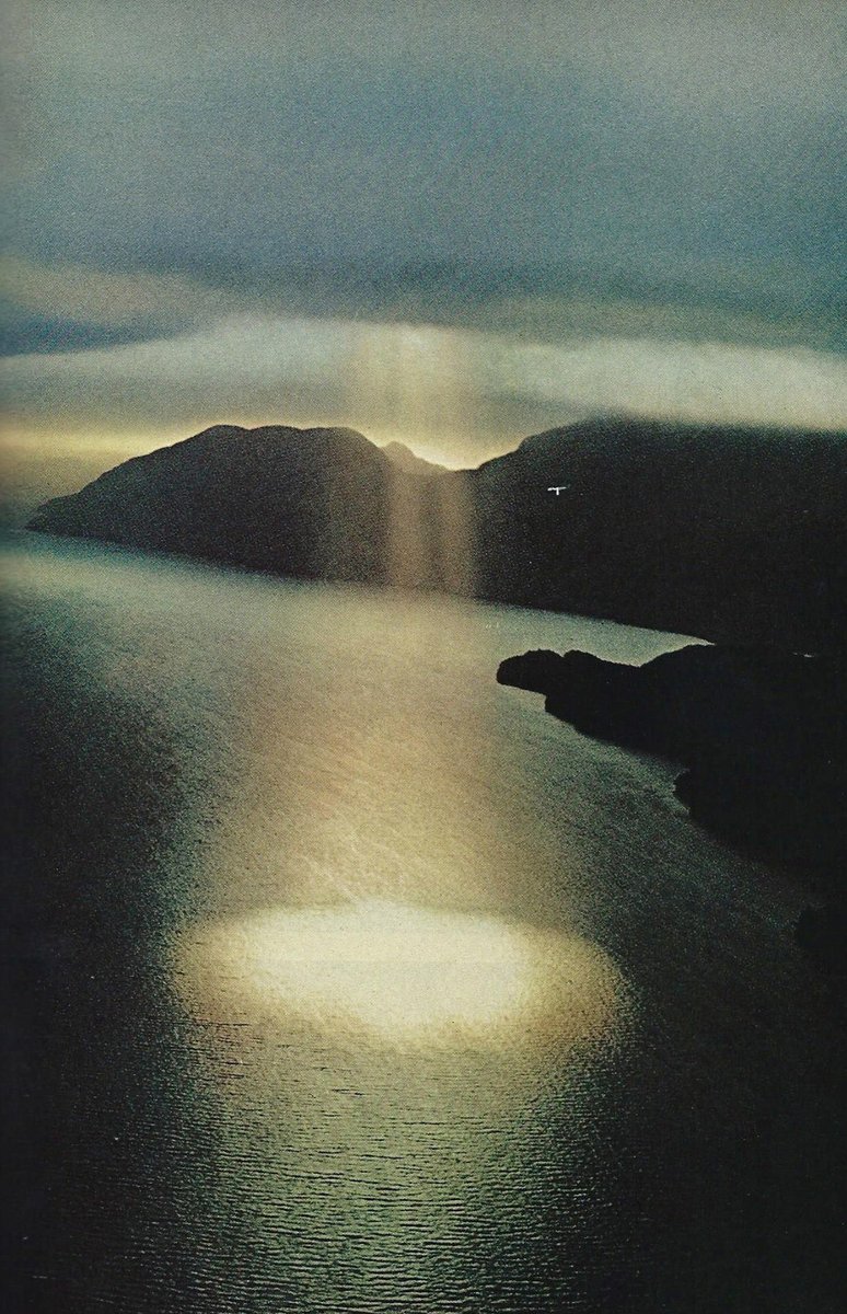 artenpedia's tweet photo. A single shaft of sunlight breaks leaden clouds on New Zealand’s Dusky Sound - September 1971 https://t.co/HQioRfhieH
