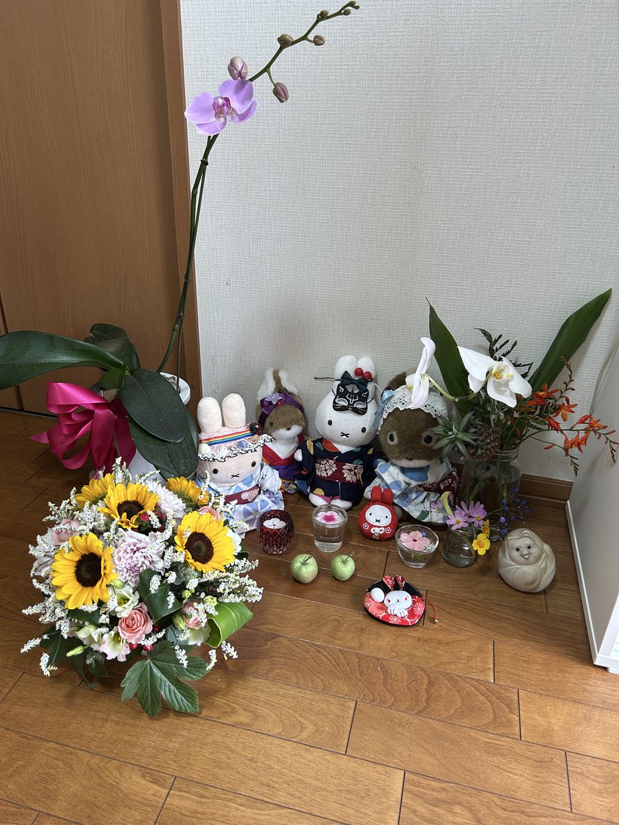 向日葵のフラワーアレンジとピンクの胡蝶蘭と白い胡蝶蘭と青い霞草と庭