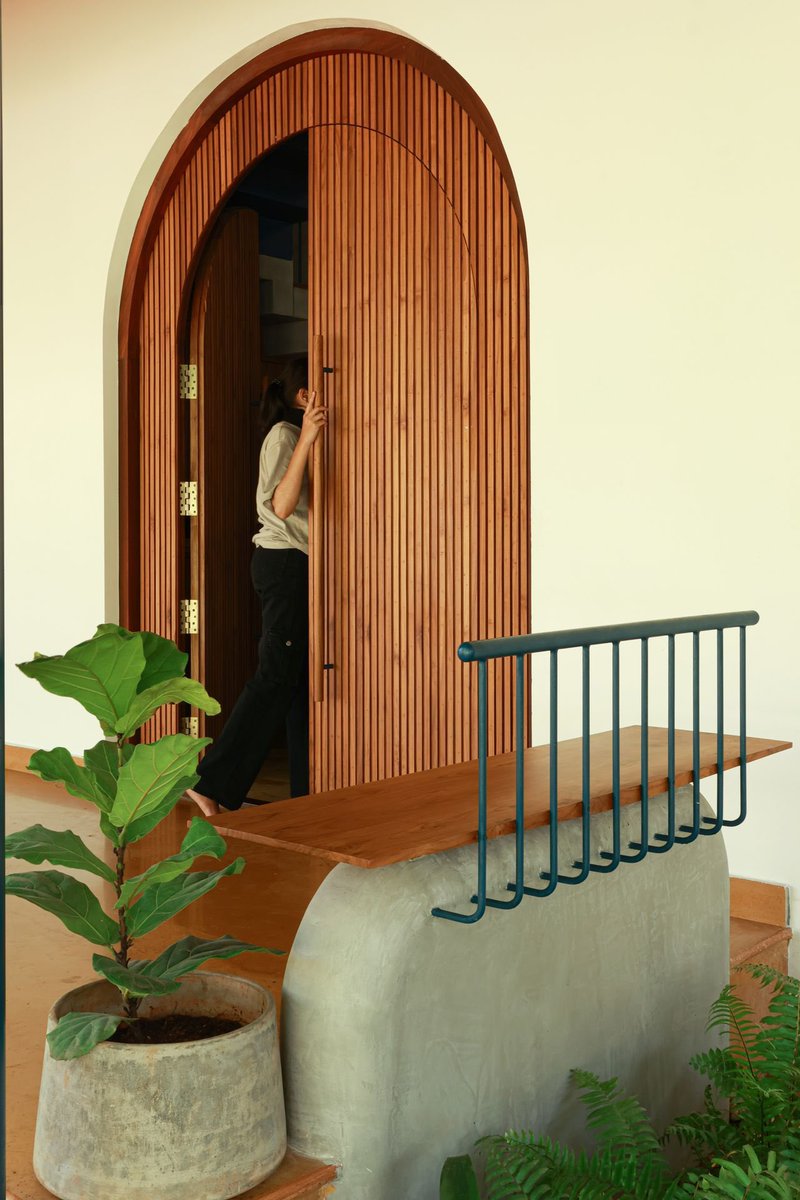 shavnyuyngah's tweet photo. A civil engineer spent his childhood in a quiet Kerala home, moved away for work, and never stopped wanting to come back to that feeling. When the pandemic gave him a reason to work from home, he built one, this time in Elathur, Kozhikode, drawing from both Kerala and Goan vernacular he had come to love while traveling for work.

He called on Aslam Karadan and Sham Salim, longtime friends before they were ever his architects, and together they built a 4,700 square foot home around one belief, that imperfection is not something to hide.

Wood, laterite stone, and terracotta roof tiles came from a demolished public building nearby, material most of us would call waste sitting on a demolition site. Old shopfront planks became the floor, the facade, the door and window frames. Timber salvaged from old doors was rebuilt into a staircase, and the architects left the original bolt holes visible on purpose, proof of a former life instead of something sanded away.

The living room opens on one side to a courtyard, and on the other to a koi pond and garden, the exact kind of space where a family actually lives, eats, argues, and remembers each other. Lime plaster, mixed to recipes carried by specialist craftsmen, coats the walls, the counters, even the toilet floors, a finish that only grows more beautiful with age instead of cracking the way cement does.

None of this is imported knowledge. Courtyards, reclaimed material, lime finishes, our own continent carries the same inheritance. We walk past it every day and reach instead for tiled walls and sealed cement boxes, calling that progress.

Kerala home. Elathur, Kozhikode, India.
Architects: Aslam Karadan & Sham Salim, Aslam Sham Architects. Photography: Abhimanyu K.V